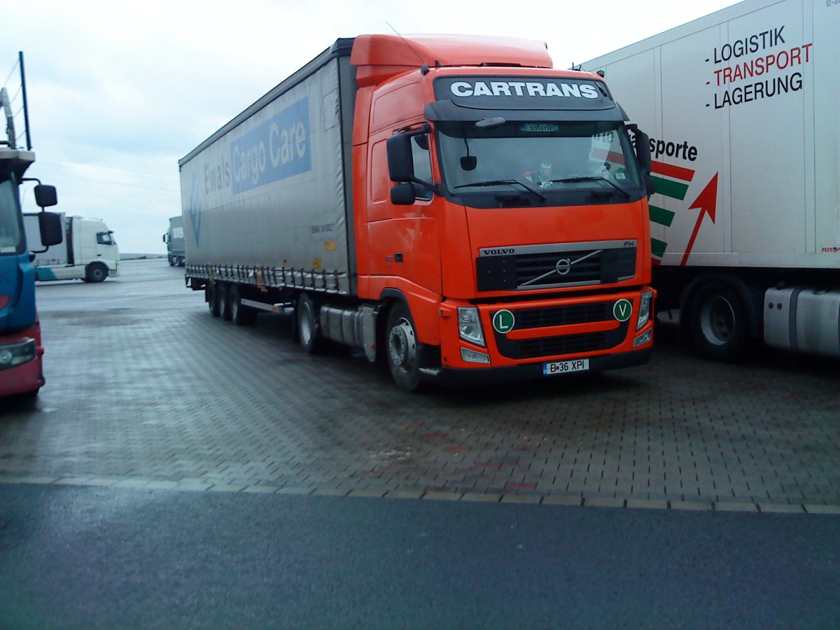 SZM Volvo FH der Spedition Cartrans mit Pritsche-Planen-Auflieger der Spedition Ewals Cargo Care auf dem Autohof in Grnstdt am 19.12.2013