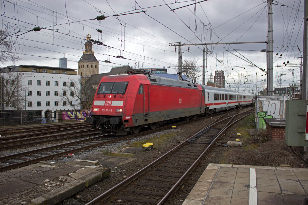 Unter dem reich verzierten Turm der St. Ursula-Kirche fährt 101 084 mit einem InterCity in den Kölner Hauptbahnhof ein.