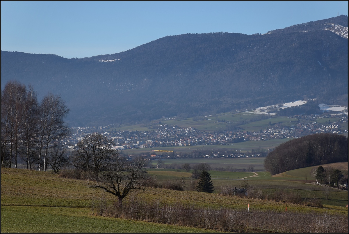 Viel Landschaft, wenig Zug am Jura.

Ein Postzug wird von einer Re 4/4 II auf der Jurasüdfusslinie nach Bettlach gezogen. Januar 2022. 
