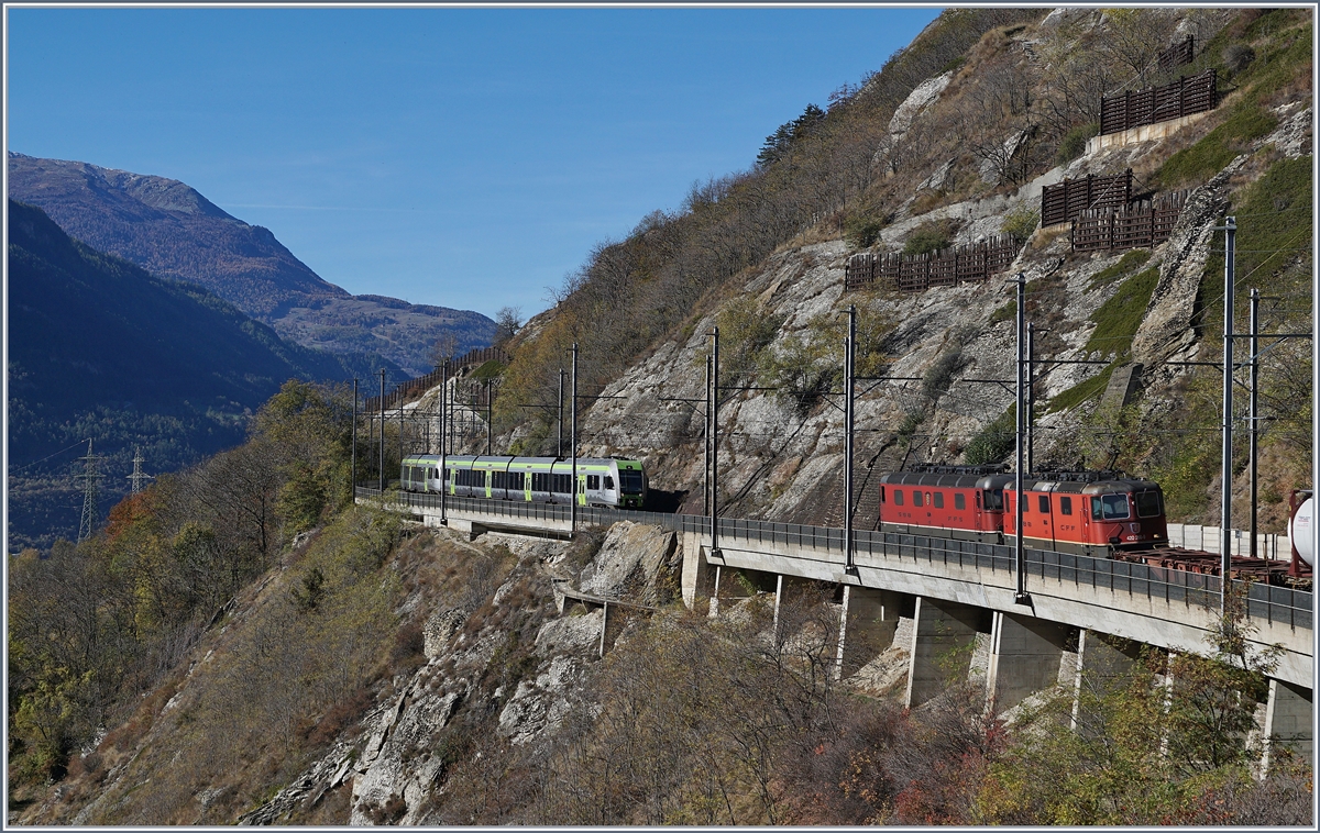 Viel Verkehr auf der Lötschberg Südrampe in der Nähre von Lalden: Während eine  Re 10/10  mit einem Güterzug bergwärts fährt, kommt von Lalden ein  Lötschberger  auf der Fahrt nach Brig entgegen. 
25. Okt. 2017