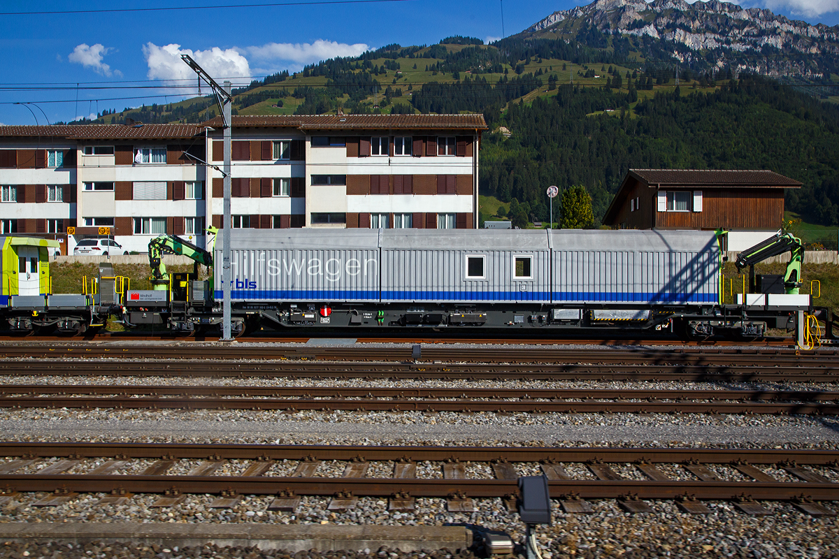 Vierachsiger BLS Hilfswagen (für den Einsatz am Lötschberg-Basistunnel) Xas 99 85 9277 502 – 2 CH-BLSN der BLS Netz AG am 08.09.2021 beim Bahnhof Frutigen (aufgenommen aus einem Zug heraus).

Der Wagen hat zwei hydraulische Ladekrane und ist mit einem Dieselmotor (mit 126 kW Leistung) ausgerüstet und kann mit geringer Geschwindigkeit (bis zu10 km/h) die letzte Wegstrecke in Eigenfahrt zum Einsatzort zurücklegen. Die Anfahrt zum Einsatzort erfolgt im Zugverband. Gebaut wurde zwei dieser Wagen 2004 von Windhoff  Bahn- und Anlagentechnik GmbH in Rheine.

TECHNISCHE DATEN (laut Anschriften):
Spurweite: 1.435 mm (Normalspur)
Länge über Puffer: 26,3 m
Eigengewicht: 74,0 t
Höchstgeschwindigkeit geschleppt: 100 km/h
Max. Ladegewicht: 16 t (ab Streckenklasse D)
