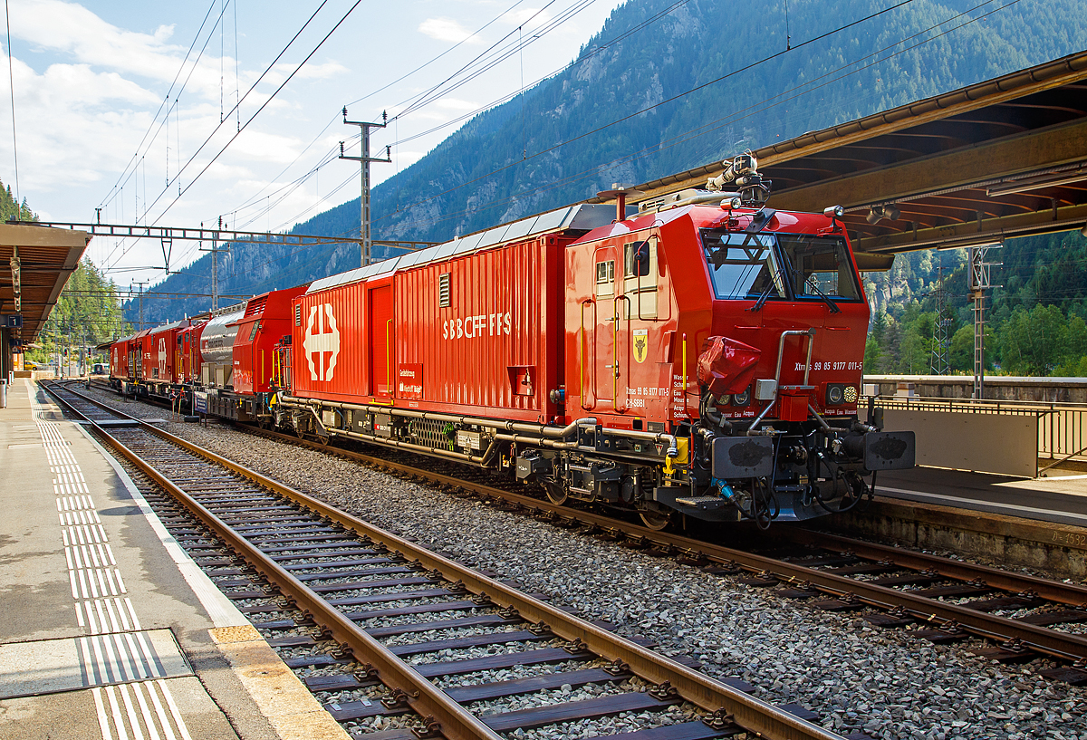 Von der anderen Seite....

Der Erstfelder SBB Lösch- und Rettungszug 2014 „Uri“ (ein vierteiliger LRZ 14) am 02.08.2019 beim Halt im Bahnhof Göschenen.
Der Lösch- und Rettungszug wurde 2014 für die SBB Infrastruktur, Depot Erstfeld, gebaut und besteht aus dem:
Gerätefahrzeug - Xtmas 99 85 9177 011-5 CH-SBBI;
Tanklöschwagen - Xans 99 85 9375 011-5 CH-SBBI;
Rettungsfahrzeug 2 - Xtmas 99 85 9174 011-8 CH-SBBI; sowie
Rettungsfahrzeug 1 - Xtmas 99 85 9174 021-7 CH-SBBI;

Die vorletzte Generation der Lösch- und Rettungszüge (LRZ 2014) ist vierteilig und besteht aus einem Tanklöschwagen, einem Gerätefahrzeug und zwei Rettungsfahrzeugen. Der Antrieb erfolgt mit je zwei MTU-Dieselpowerpacks (6-Zylinder Turbo geladener Dieselmotor von MTU, Partikelfilter, Turbogetriebe mit eingebauten Retarder und Kühlsystem) nach EU-Abgas-Emissionsstufe IIIA Norm, mit je 390 kW Leistung über die beiden Rettungs- sowie das Gerätefahrzeug. Der Lösch- und Rettungszug hat so eine installierte Gesamtleistung von 2.340 kW, eine Höchstgeschwindigkeit von 100 km/h und kann Anhängelasten von 940 Tonnen bei einer Steigung von 27 Promille bewegen. Der gesamte Atemluftvorrat des Zuges beträgt 1.980.000 Normliter und wird in 132 Speicherflaschen, die ein Volumen von 50 Litern haben, mit 300 Bar Druck gelagert. An verschiedenen Orten in den Innenräumen und auf den Plattformen sind Anschlüsse für die Atemluftversorgung vorhanden. Daran können separate Atemschutzmasken oder das tragbare Atemschutzgerät mit Geber- und Nehmerschlauch angeschlossen werden. Alle Führerstandkabinen sind druckdicht und verfügen über eine Atemluftversorgung, welche einen Überdruck erzeugt. In den Führerstandkabinen des Gerätefahrzeugs und des Tanklöschwagens ist zusätzlich ein Bedienpult für die Feuerlöschtechnik eingebaut.
Zwischen 4 und 5 Stunden ist ein autonomer Betrieb des LRZ möglich.

Im Einsatz wird der Zug in zwei Einheiten geteilt. Die erste Einheit aus Gerätefahrzeug und Tanklöschwagen dient der Feuerbekämpfung und dem Bergungsarbeiten. Die zweite Einheit, bestehend aus zwei Rettungsfahrzeugen übernimmt im Shuttleverkehr den Personentransport zu einem sicheren Ort.

Für den Gotthard-Basistunnel (GBT) werden zwei dieser LRZ 14 vorgehalten, dieser steht beim neuen Erhaltungs- und Interventionszentren (EIZ) Erstfeld und ein weiterer beim EIZ Biasca. Für jeden Zug wird rund um die Uhr (7x24 h) eine Besatzung mit je 5 Mann vorgehalten. Die Mannschaften der Lösch- und Rettungszüge sind an deren Standorten kaserniert. Das ermöglicht, dass sie auch in der Nacht innerhalb weniger Minuten einsatzbereit sind. Die Züge sind innerhalb 5 Minuten startklar. Im Ereignisfall erfolgt dann eine entsprechende Verstärkung durch externe Einsatzkräfte, wie Feuerwehr, Sanität, etc..

Technische Daten Rettungsfahrzeug 1 und 2:
Ausrüstung Rettungscontainer:
Außenluftunabhängiger Hauptraum mit leichtem Überdruck, zugänglich durch Schleusenraum;
Platz für etwa 60 Personen oder 40 Personen und 6 Liegen
20 Atemschutzgeräte mit angeschlossenem Geber- und Nehmerschlauch
Tragbahren faltbar, Rettungsbretter, Schaufelbahren, Vakuummatratzen
Material für lebensrettende Sofortmaßnahmen und Sanitätsmaterial
Anschlüsse für die Versorgung von Patienten mit Medizinsauerstoff
Raumüberwachungsgeräte für Sauerstoff und Kohlendioxid
Brandschutzausrüstung der Mannschaft (Jacken, Hosen, Stiefel, Helme)
Explosionsmessgerät und Wärmebildkameras
Ausrüstung Rettungsplattform
Treppenmodul2 Schwenkarme mit Kettenzug
2 Feste LED Scheinwerfer
Prüf- und Erdungsgarnituren für die Fahrleitung

TECHNISCHE DATEN (Fahrzeug):
Hersteller Basisfahrzeug: Windhoff Bahn- und Anlagentechnik GmbH
Basisfahrzeug Typ: WINDHOFF MPV
Hersteller Rettungscontainer und Atemluftanlage: Dräger Safety AG
Spurweite: 1.435 mm (Normalspur)
Achsfolge: Bo´Bo´
Eigengewicht: ca. 70.000 kg
Max. Zuladung: 7.000 kg
Länge über Puffer: 22.060 mm
Drehzapfenabstand: 15.500 mm
Achsabstand im Drehgestell: 2.600 mm
Treibraddurchmesser: 920 mm (neu)
Höhe der Containerauflage: 1.220 mm
Höchstgeschwindigkeit: 100 km/h (eigen und geschleppt)
Leistung: 2 x 390 kW
Dieselmotor: 2 x MTU-Dieselpowerpack (6-Zylinder Turbo geladener Dieselmotor von MTU, Partikelfilter, Turbogetriebe mit eingebauten Retarder und Kühlsystem)
Kleinster befahrbarer Gleisbogen: R 120 m

Technische Daten Tanklöschwagen:
Ausrüstung Tanklöschwagen:
1 Frontmonitor an Führerkabine, Leistung 800 l/Min. bei 8 Bar, Wurfweite ca. 35 m (Wasser)
1 Wasser-/Schaumwerfer auf Kabinendach, Leistung 2400 l/Min. bei 8 Bar, Wurfweite ca. 70 m (Wasser), ca. 60 m (Schaum)
Fahrzeugfront, Selbstschutzdüsen 2 × 75 l/Min. und 1 × 150 l/Min.
Abgänge getrennt für Wasser – Wasser/Schaum
Aufbaubarer Wasser-/Schaumwerfer mit 1200 l/Min.
Aufbaubare Hydroschilder mit 720 und 1800 l/Min.
feste LED-Scheinwerfer
Schlauchmaterial 1.000 m (Schlauchgrößen 40 mm, 55 mm, 75 mm)
Teilstücke, Hohlstrahlrohre, Schwer- und Kombischaumrohre
Handfeuerlöscher (Schaum, CO2)
Prüf- und Erdungsgarnituren für die Fahrleitung

Maschinenraum Tanklöschwagen:
Dieselmotor Deutz (238 kW / 324 PS), 6 Zylinder mit vollautomatischem Partikelfilter welcher die Abgasnorme Stage IIIB erfüllt und angeflanschtem Pumpenaggregat von Vogt
Druckpumpe 6000 l/Min. bei 10 Bar
Schaummittelpumpe 500 l/Min., 0–6 % Zumischrate
Hochdruckpumpe 500 l/Min. bei 40 Bar

TECHNISCHE DATEN (Fahrzeug):
Hersteller Untergestell: Josef Meyer AG
Hersteller Fahrzeug Oberbau: Windhoff Bahn- und Anlagentechnik GmbH
Hersteller Atemluftanlage: Dräger Safety AG
Hersteller Feuerlöschtechnik: Vogt AG
Spurweite: 1.435 mm (Normalspur)
Anzahl der Achsen: 4 in zwei Drehgestellen
Länge über Puffer: 17.040 mm
Drehzapfenabstand: 12.000 mm
Achsabstand im Drehgestell: 1.800 mm
Eigengewicht: 41.000 kg
Dienstgewicht 90.000 kg
Löschwasservorrat: 45.000 Liter
Schaumextrakt-Vorrat: 1.500 Liter

Technische Daten Gerätefahrzeuge:
Arbeitsmodul/Generator:
Generator 65 kVA für Bordnetz, Dieselmotor Deutz (erfüllt Abgasnorm IIIB, ausgerüstet mit einer integrierten Abgasnachbehandlung und aktiver Regeneration mittels eines DPF/Brenners).
Atemluftfilteranlage und Abfüllstation für tragbare Atemluftflaschen.

Feuerlöschanlage:
1 Frontmonitor an Führerkabine, Leistung 800 l/Min. bei 8 Bar, Wurfweite ca. 35 m (Wasser)
1 Wasser-/Schaumwerfer auf Kabinendach, Leistung 2400 l/Min. bei 8 Bar, Wurfweite ca. 70 m (Wasser), ca. 60 m (Schaum)
Fahrzeugfront, Selbstschutzdüsen 2 × 75 l/Min. und 1 × 150 l/Min.

Ausrüstung:
Motorspritze (Typ 1, mobil, 800 l/Min. bei 8 Bar, resp. nach Umbau Lenzpumpe 2700 l/Min. bei 1,5 Bar mit Saugschläuchen)
Diverses Ölwehrmaterial – Ölbindemittel, Feuerlöscher (Schaum, Pulver, CO2), Werkzeug, Explosionsgeschützte Handlampen und Wärmebildkameras
Beleuchtungsmaterial – Scheinwerfer (1.000 W)
ELRO-Pumpe mit Saug-/Druckschläuchen
Schienenrollwagen
Rettungskettensäge, Trennschleifer, Rettungsschere/Rettungsspreizer, Pioniermaterial, Leiter und Absperrmaterial
Evakuierungsstege
Hilfskupplungen für Fahrzeuge mit automatischer Kupplung
Kran Palfinger PC 3800 mit Seilwinde

TECHNISCHE DATEN (Fahrzeug):
Hersteller Basisfahrzeug: Windhoff Bahn- und Anlagentechnik GmbH
Basisfahrzeug Typ: WINDHOFF MPV
Hersteller Arbeitsmodul: Dräger Safety AG
Hersteller Feuerlöschtechnik: Vogt AG
Spurweite: 1.435 mm (Normalspur)
Achsfolge: Bo´Bo´
Eigengewicht: 71.900 kg
Dienstgewicht: 80.000 kg
Länge über Puffer: 22.060 mm
Drehzapfenabstand: 15.500 mm
Achsabstand im Drehgestell: 2.600 mm
Treibraddurchmesser: 920 mm (neu)
Höhe der Containerauflage: 1.220 mm
Höchstgeschwindigkeit: 100 km/h (eigen und geschleppt)
Leistung: 2 x 390 kW
Dieselmotor: 2 x MTU-Dieselpowerpack (6-Zylinder Turbo geladener Dieselmotor von MTU, Partikelfilter, Turbogetriebe mit eingebauten Retarder und Kühlsystem)
Kleinster befahrbarer Gleisbogen: R 120 m

Quellen: SBB und Anschriften