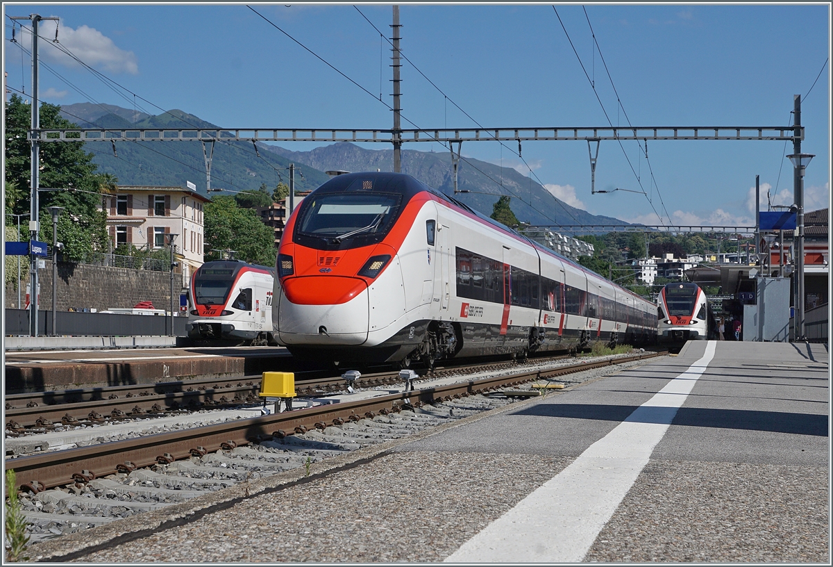 Von den Tilo RABe 524 114 als RE nach Locarno und dem RABe 524 108 nach Como eingerahmt ist in Lugano einer der beiden, den IC 21 663 bildenden RABe 501  Giruno  zu sehen.

23. Juni 2021 