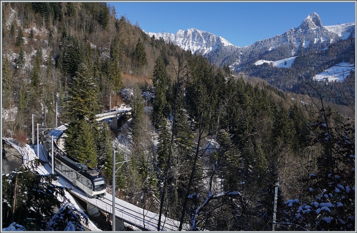 Während der Blick über die im Hintergrund verschneiten Berge gleitet, ist im Vordergrund eine CEV MVR ABeh 2/6 als Regionalzug auf dem Weg von Les Avants nach Montreux und erreicht in Küzre Sendy-Sollard.

11. Jan. 2021