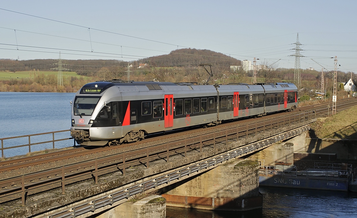 Wegen des laufenden Insolvenzverfahrens endeten am 31.01.2022 die Verkehrsverträge zwischen der  Abellio Rail GmbH, die sich im Eigentum der Niederländischen Staatsbahn befindet, und den SPNV-Trägern in NRW. Die bisherigen Abellio-Verträge gingen an DB Regio GmbH, National Express und VIAS. Zu den von Abellio betriebenen Linien gehörte auch der RE 16 von Essen über Hagen nach Siegen. Inzwischen fährt hier DB-Regio, wie dieses Foto vom ET 23 2103 auf der Obergrabenbrücke bei Wetter (Ruhr) mit DB-Keks zeigt.