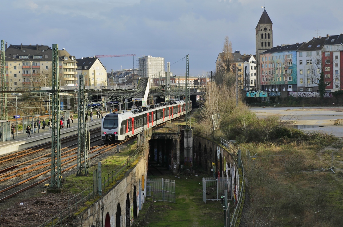 Wegen des laufenden Insolvenzverfahrens endeten am 31.01.2022 die Verkehrsverträge zwischen der  Abellio Rail GmbH, die sich im Eigentum der Niederländischen Staatsbahn befindet, und den SPNV-Trägern in NRW. Die bisherigen Abellio-Verträge gingen an DB Regio GmbH, National Express und VIAS. Den Betrieb auf der Linie RE 19 von Düsseldorf nach Arnhem/Niederlande übernahm VIAS. Auf dem Bild vom 04.03.2020 ist ein RE 19-Doppel mit dem ET 25 2208 am Schluss bei der Durchfahrt in Düsseldorf-Wehrhahn zu sehen.