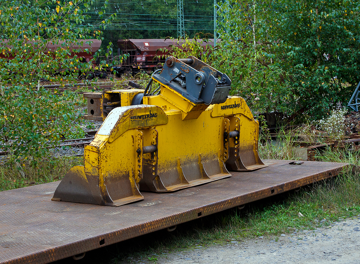 WINDHOFF Schwellenwechselgerät APE (HSW) der Schweerbau, zum Anbau an einen Zweiwege-Bagger, abgestellt am 20.09.2021 beim Bahnhof Betzdorf (Sieg).

Das Anbaugerät wurde 2017 von der WINDHOFF 
Gleisbautechnik GmbH (Rheine) unter der Fabriknummer APE20172113 gebaut.

Das hydraulische Schwellenwechselgerät HSW ist ein Multifunktionsaggregat für den Aus- und Einbau des Gleisschotterbettes sowie für das Wechseln von Holz- und Betonschwellen. Die Aufnahme des Schwellenwechselgerätes sowie die hydraulische Energieversorgung erfolgt vom Zweiwege-Bagger.

Der Aus- und Einbau der Schwellen erfolgt durch die angebaute hydraulische, 360° endlos drehbare Schwellenzange angebaute. Die Positionierung und Konstruktion dieser Zange wurde so gewählt, dass ein sicherer und schonender Aus- und Einbau aller gängigen Holz- und Betonschwellen gewährleistet ist. Es ist kein Wechseln der Zange erforderlich, auch bei unterschiedlichen Schwellenarten.

Um eine hohe Effektivität des Schwellenwechselgerätes zu erreichen, wurde das maximale Volumen bei den fest montierten Schaufelsegmenten gewählt.
Die Grabtiefe des Schwellenwechselgerätes HSW ist durch zwei verstellbare Rollen (die dann auf dem Gleis aufliegen) variabel und somit individuell einstellbar.

Technische Daten:
Gewicht: 1.400 kg
Breite: 2.750 mm
Betriebsdruck: 250 bar
Spurweite: 1.435 mm  
