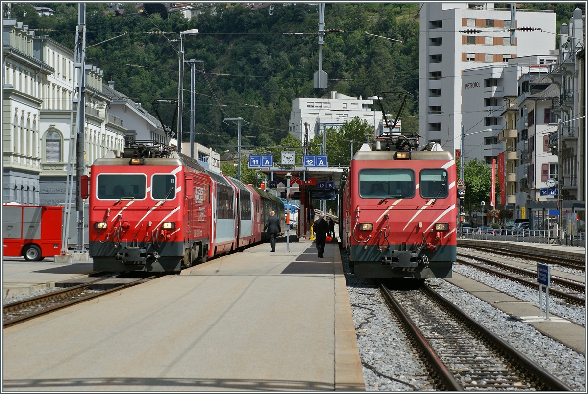 Zwei MGB HGe 4/4 warten in Brig mit einem Glacier-Express und Regionalzug Richtung Zermatt auf die Abfahrt.
16. Aug. 2014