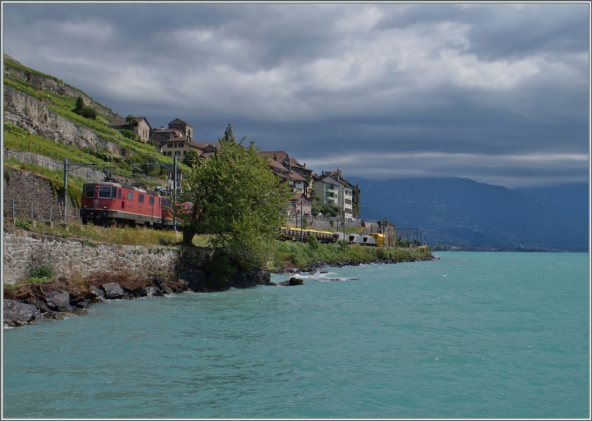 Zwei Re 4/4 II mit einem Güterzug am etwas aufgewühlten Lac Leman bei St-Saphorian.
8. Juli 2015