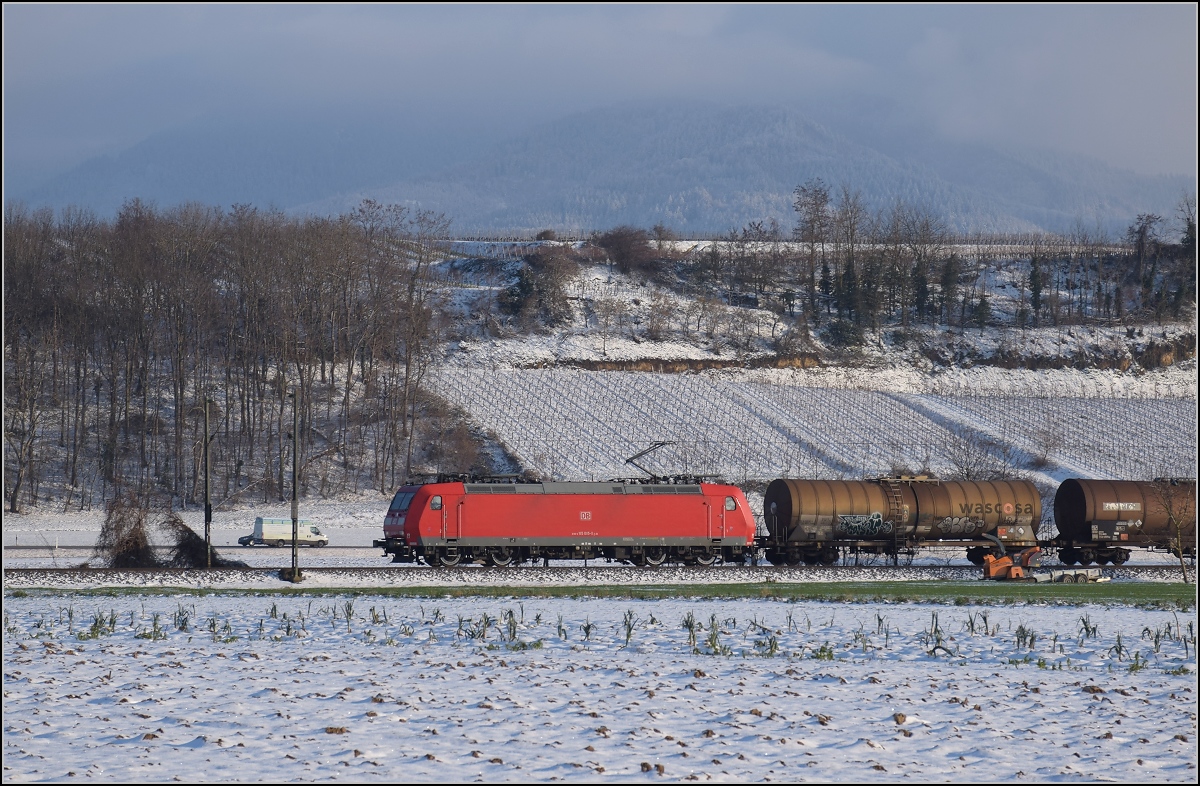 Zwischen Belchensystem und Blauendreieck. 

Captrain 185 085 ist bei Buggingen nordwärts unterwegs. Februar 2021.