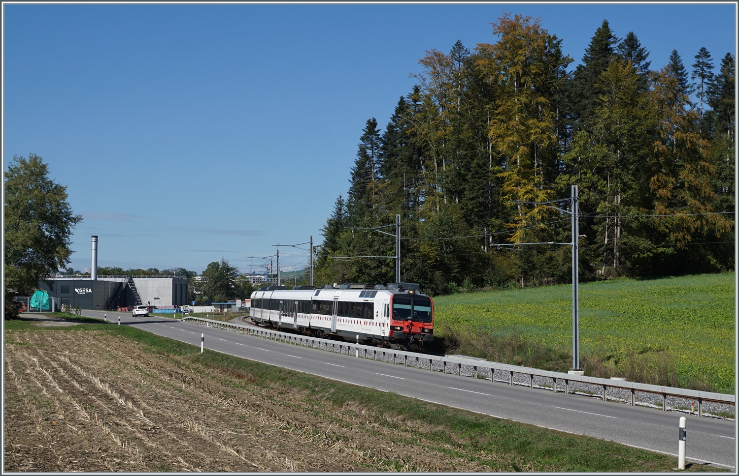 An praktisch derselben Stelle zeigt sich gut eineinhalb Jahre später ein TPF Domino auf der Fahrt nach Broc Fabrique, nun ist die Strecke umgespurt und wird im Halbstundentakt bedient, wobei die Züge bis nach Bern bzw. Düdingen verkehren.

29. Sept. 2023