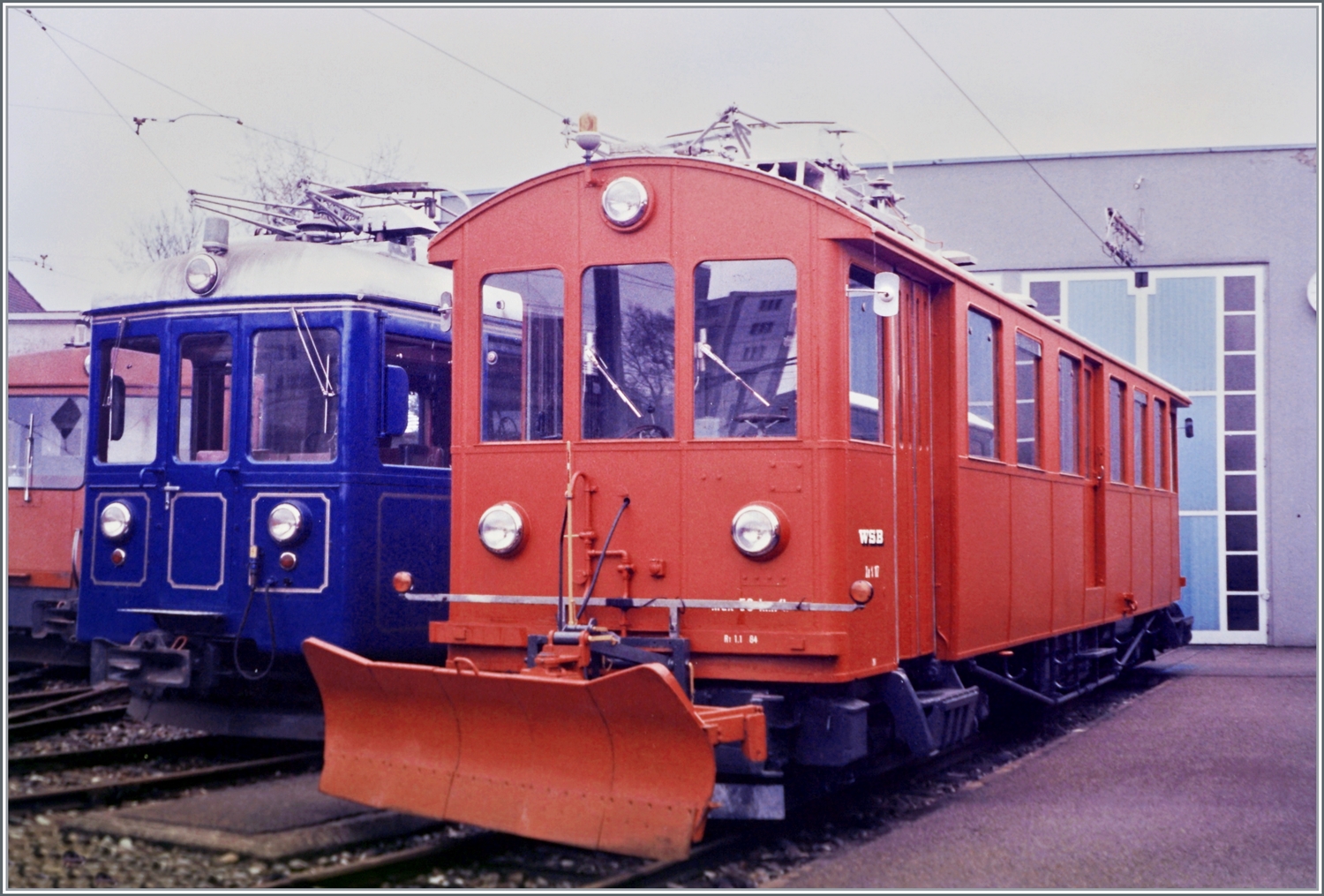 Anlässlich der Eisenbahn Amateur Delegierten Versammlung in Aarau zeigen die WSB und SBB einige Fahrzeuge. Im Bild der WSB Xe 4/4 N° 17 mit einem Schneepflug und im Hintergrund der Salontriebwagen Bse 4/4 N° 116 (Baujahr 1901/Umbau zum Salonwagen 1982).
Analogbild vom April 1985