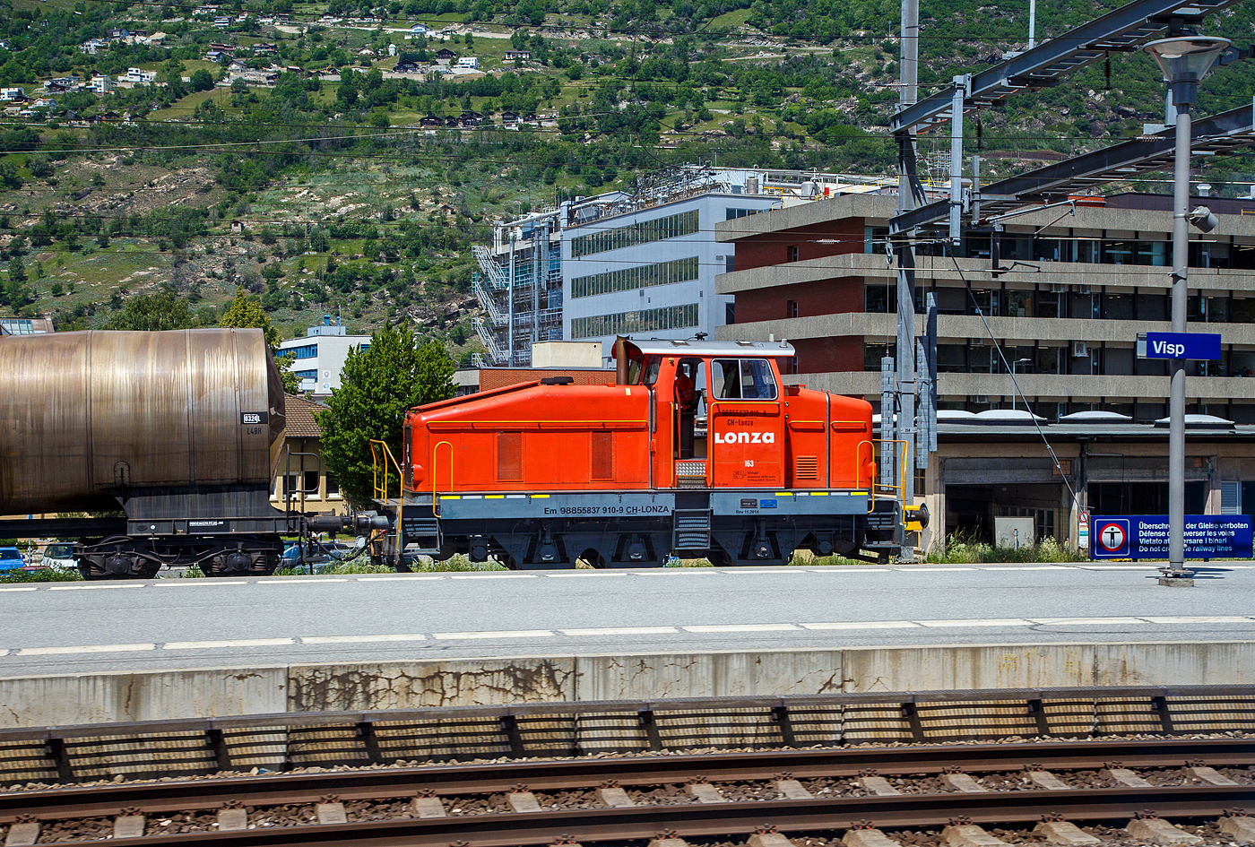 Aus dem Zug heraus, die Em 3/3 163  Rene  (98 85 5837 910-9 CH-LONZA) eine Henschel DHG 500 C der Lonza Group AG (Visp), am 26.05.2023 mit einem Kesselwagenzug im Bahnhof Visp.

Die Henschel  DHG 500 C wurde 1968 von Henschel in Kassel unter Fabriknummer  31239  gebaut und war erst als Mietlok im Einsatz. Im Jahr 1971 verkaufte sie dann Henschel an die Lonza AG in die Schweiz.
2014 wurde die Lok von der LSB Lok Service Balmer AG in Hinwil komplett neu revidiert und remotorisiert.