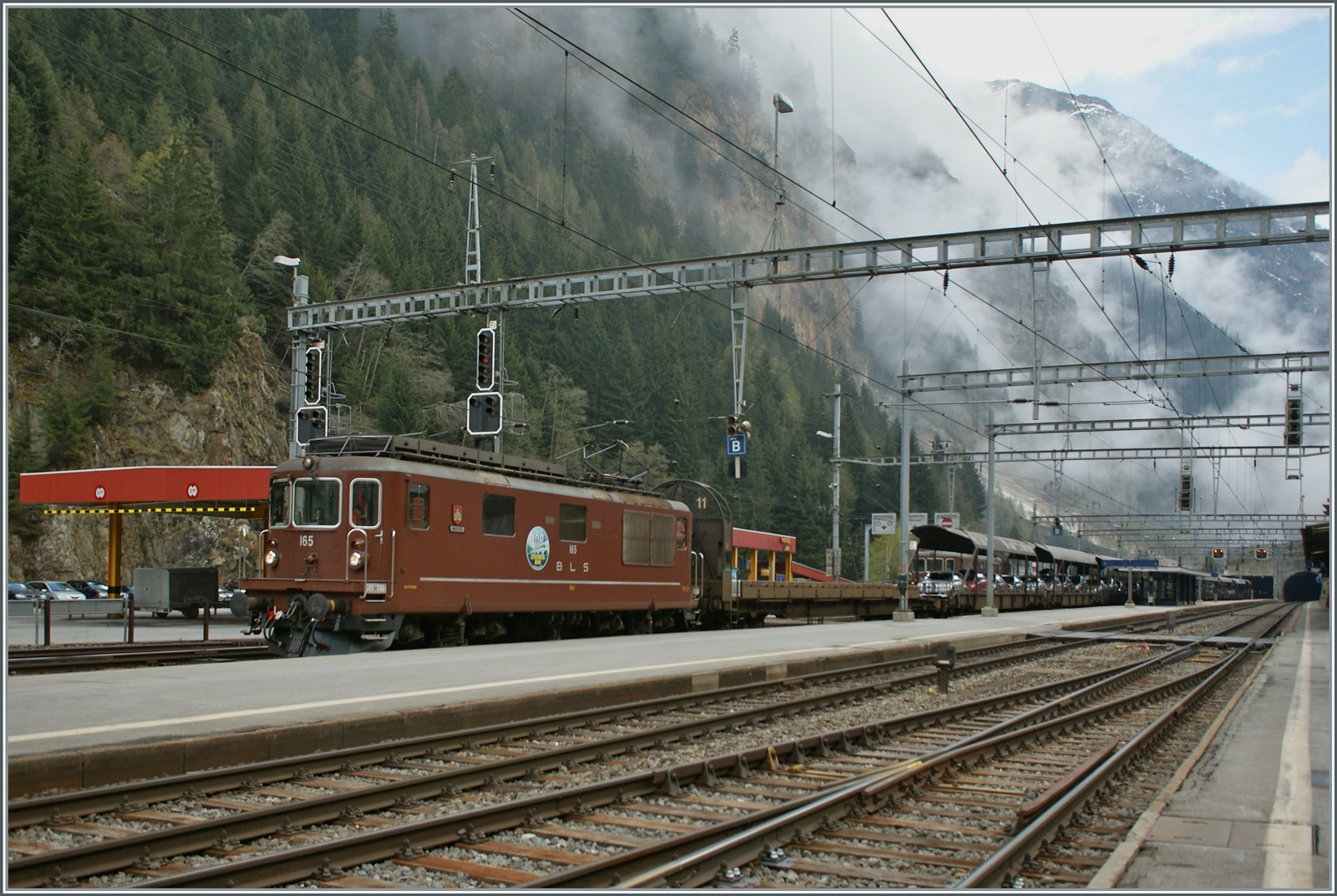 BLS Re 4/4 163 - 165 von 1967, als Ae 4/4 II 263- 265 abgeliefert; die Re 4/4 165  Moutier  verlässt mit einem Tunnelautozug Goppenstein in Richtung Kandersteg. 

4. Mai 2013