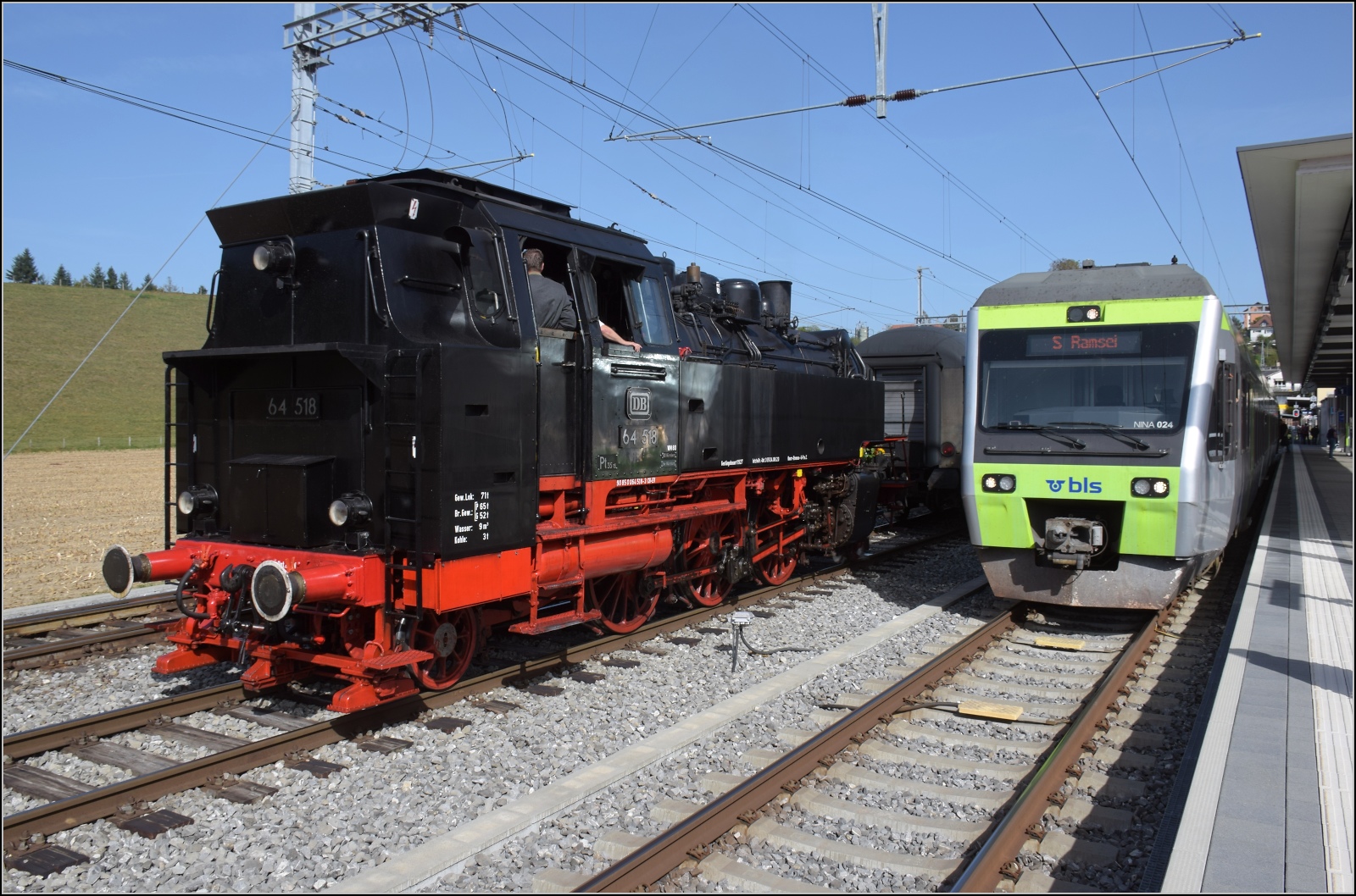 Dampftage Huttwil mit frisch genesenem Bubikopf. 

64 518 rangiert zum Wasserfassen, daneben wartet Nina RABe 525 024 auf Abfahrt. Oktober 2023.