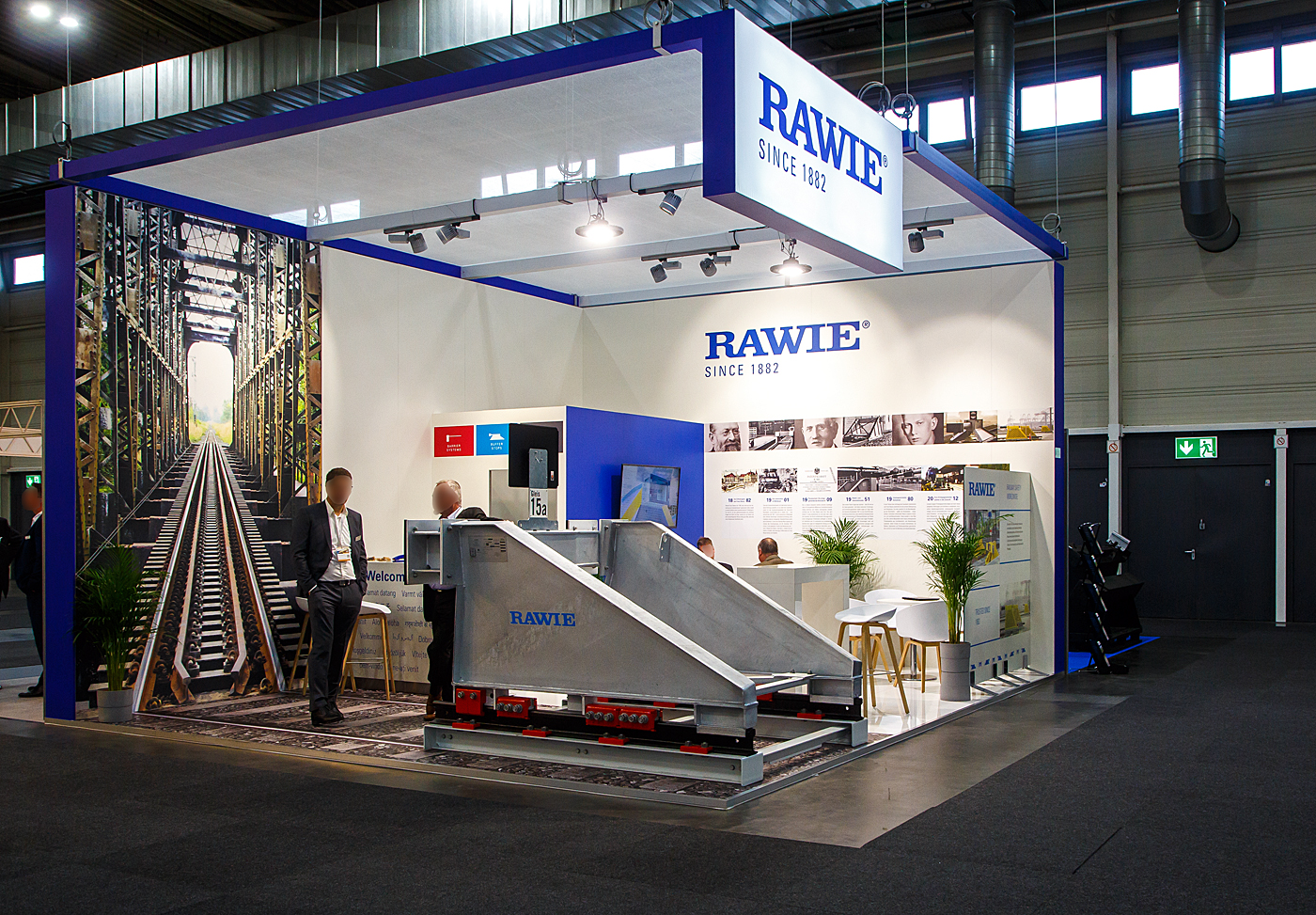 Das wusste ich auch nicht, der Ingenieur Franz Rawie aus Osnabrück ist der Erfinder des Prellbocks. Heute die A. RAWIE GMBH & CO. KG, diese hatte auch einen Stand auf der 28. Internationale Ausstellung Fahrwegtechnik 2022 (iaf) in Münster, hier am 31 Mai 2022, und stellte auch einen Brems-Prellbock aus. 

Bremsprellböcke können deutlich höhere Energien als alle Arten von Festprellböcken aufnehmen. Sie werden in der Regel auf den Fahr- und gegebenenfalls Zusatzschienen mit speziellen Klemmen befestigt, die untereinander mit Schrauben verspannt sind. Diese Klemmen erzeugen eine hohe Reibung und können so beispielsweise einen Zug mit einer Masse von 850 Tonnen auf sieben Metern von 15 km/h bis zum Stillstand abbremsen, ohne die Fahrzeuge zu beschädigen. Ist mit höheren Massen oder Geschwindigkeiten zu rechnen, wird ein Bremsprellbock zusätzlich mit Schleppschwellen ausgerüstet. Diese erfordern jedoch eine Betonplatte als Untergrund und damit einen deutlich höheren Bauaufwand.

Entwickelt und patentiert wurde der Bremsprellbock von Ingenieur Franz Rawie aus Osnabrück, der nach dem Eisenbahnunfall im Centralbahnhof Frankfurt nach einer Lösung zum sicheren Abbremsen von Zügen suchte. Am 06. Dezember  1901 fuhr eine Lokomotive mit dem Ostende-Wien-Express (Zugleiter des Orientexpresses) mitten in die gedeckten Tische des Restaurants der 1. und  2. Klasse vom Centralbahnhof Frankfurt a.M., verletzt wurde keiner, ab der war der Anlass zur Erfindung von Franz Rawie. Bereits 1907 erprobte er sein Bremssystem „Nummer 1“ im Bahnhof Ibbenbüren. Da die Bahn keine ihrer Lokomotiven für den Versuch hergeben wollte, beschleunigte man einige alte Güterwagen durch Pferde und ließ sie auf den Bremsprellbock auflaufen, der sie wirksam abbremste. Danach wurden in den Bahnhöfen Schneidemühl, Duisburg und im Bremer Bahnhof in Osnabrück weitere Bremsprellböcke zu Testzwecken aufgestellt. Nachdem alle Versuche mit dem Bremsprellbock zufriedenstellend ausgefallen waren, wurde 1910 der Frankfurter Hauptbahnhof als erstes mit ihnen ausgestattet.
