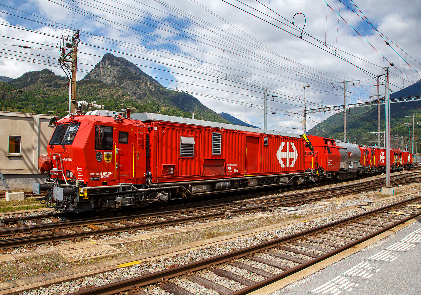 Der 4-teilige Lösch- und Rettungszug  „Brig“ (ein vierteiliger LRZ 18) der SBB Infrastruktur erreicht am 25.05.2023 seinen Heimatbahnhof Brig.

Der Lösch- und Rettungszug wurde 2018 für die SBB Infrastruktur, Depot Brig, gebaut und besteht aus dem:
Rettungsfahrzeug 1 - Xtmas 99 85 9174 023-3 CH-SBBI;
Rettungsfahrzeug 2 - Xtmas 99 85 9174 013-4 CH-SBBI;
Tanklöschwagen - Xans 99 85 9375 013-1 CH-SBBI; sowie
Gerätefahrzeug - Xtmas 99 85 9177 013-1 CH-SBBI

Die neuste Generation der Lösch- und Rettungszüge (LRZ 2018) ist vierteilig und besteht aus einem Tanklöschwagen, einem Gerätefahrzeug und zwei Rettungsfahrzeugen. Der Antrieb erfolgt mit je zwei MTU-Dieselpowerpacks (6-Zylinder Turbo geladener Dieselmotor von MTU, Partikelfilter, Turbogetriebe mit eingebauten Retarder und Kühlsystem) nach EU-Abgas-Emissionsstufe IIIA Norm, mit je 390 kW Leistung über die beiden Rettungs- sowie das Gerätefahrzeug. Der Lösch- und Rettungszug hat so eine installierte Gesamtleistung von 2.340 kW (6 x 390 kW), eine Höchstgeschwindigkeit von 100 km/h und kann Anhängelasten von 940 Tonnen bei einer Steigung von 27 Promille bewegen, in der Ebene sogar mit einem Gewicht von über 1.600 t. Der gesamte Atemluftvorrat des Zuges beträgt 1.980.000 Normliter und wird in 132 Speicherflaschen, die ein Volumen von 50 Litern haben, mit 300 Bar Druck gelagert. An verschiedenen Orten in den Innenräumen und auf den Plattformen sind Anschlüsse für die Atemluftversorgung vorhanden. Daran können separate Atemschutzmasken oder das tragbare Atemschutzgerät mit Geber- und Nehmerschlauch angeschlossen werden. Alle Führerstandkabinen sind druckdicht und verfügen über eine Atemluftversorgung, welche einen Überdruck erzeugt. In den Führerstandkabinen des Gerätefahrzeugs und des Tanklöschwagens ist zusätzlich ein Bedienpult für die Feuerlöschtechnik eingebaut.

Zwischen 4 und 5 Stunden  ist ein autonomer Betrieb des LRZ möglich.

Im Einsatz wird der Zug in zwei Einheiten geteilt. Die erste Einheit aus Gerätefahrzeug und Tanklöschwagen dient der Feuerbekämpfung und dem Bergungsarbeiten. Die zweite Einheit, bestehend aus zwei Rettungsfahrzeugen übernimmt im Shuttleverkehr den Personentransport zu einem sicheren Ort.
