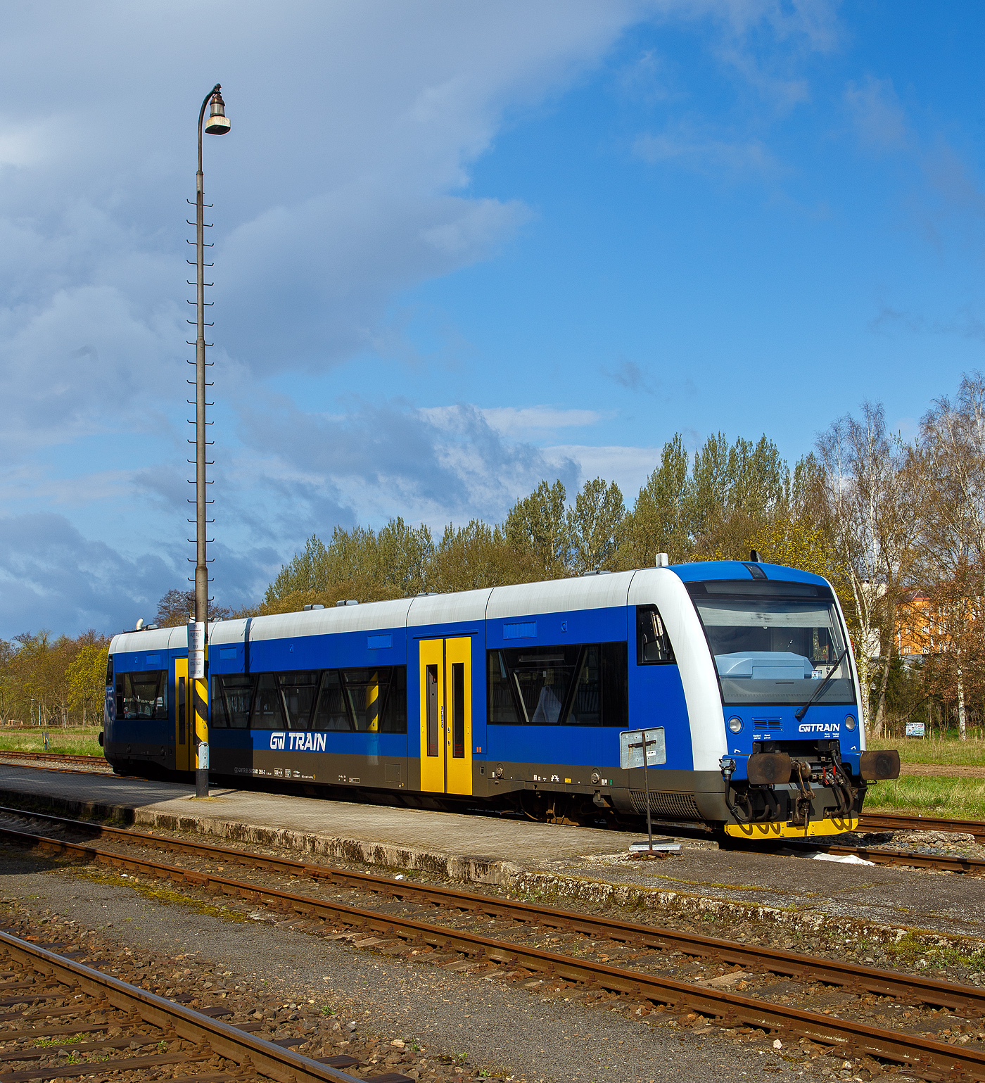 Der blaue STADLER Regio-Shuttle RS1 bzw. RegioSpider 841 265-2 (95 54 5841 265-2 CZ-GWTR) der GW Train Regio a.s. hat am 19.04.2023 von Mariánské Lázně (Marienbad) kommend den Bahnhof Karlovy Vary dolní nádraží (Karlsbad untere Bahnhof) erreicht und steht gleichauf zur Rückfahrt bereit. 

Der STADLER Regio-Shuttle RS1 wurde 1998 von ADtranz (ABB Daimler-Benz Transportation GmbH) in Berlin (heute Stadler Pankow) unter der Fabriknummer 36784 gebaut und als BOB VT 65 an die Bodensee-Oberschwaben-Bahn geliefert, von 2007 bis 2021 lief er unter der NVR-Nr. 5 80 0650 355-0 D-BOBFN. Im Jahr 2021 wurde er an die GW Train Regio a.s. nach Tschechien verkauft und war von 2021 bis 2022 als 95 80 0650 355-0 D-GWTR noch in Deutschland eingestellt.

Die GW Train Regio a.s. (bis 20. Dezember 2011 Viamont Regio a.s.) ist ein tschechisches Eisenbahnverkehrsunternehmen, mit Sitz in Ústí nad Labem.

Nachdem die Firma Viamont ab 1997 auf verschiedenen Bahnstrecken den Schienenpersonennahverkehr übernahm, gründete die Gesellschaft am 19. Juni 2008 die Viamont Regio a.s. als 100%ige Tochtergesellschaft. Diese wurde am 27. Oktober 2011 an die IDS building corporation a.s. verkauft, die sie am 20. Dezember 2011 in GW Train Regio umbenannte. Im Juni 2014 wurde das Unternehmen an die ČSAD Jihotrans a.s. weiterverkauft. Im März 2015 wurde bekannt, dass die Gesellschaft ab Fahrplanwechsel 2016 drei zusätzliche Strecken im Böhmerwald für 15 Jahre betreiben wird. GW Train Regio betreibt diese Strecken allerdings erst seit Dezember 2017 und löste die České dráhy ab. Ferner betreibt sie die Schnellzüge Plzeň–Chomutov–Most nach einer Direktvergabe mit Triebwagen der DB-Baureihe 628.

Unteranderem Betreibt die GW Train Regio a.s. die Linie auf der schöne 53 km langen Strecke (SŽDC Kursbuchstrecke 149) von Karlovy Vary dolní nádraží (Karlsbad untere Bahnhof) über Bečov nad Teplou (Petschau) nach Mariánské Lázně (Marienbad).
