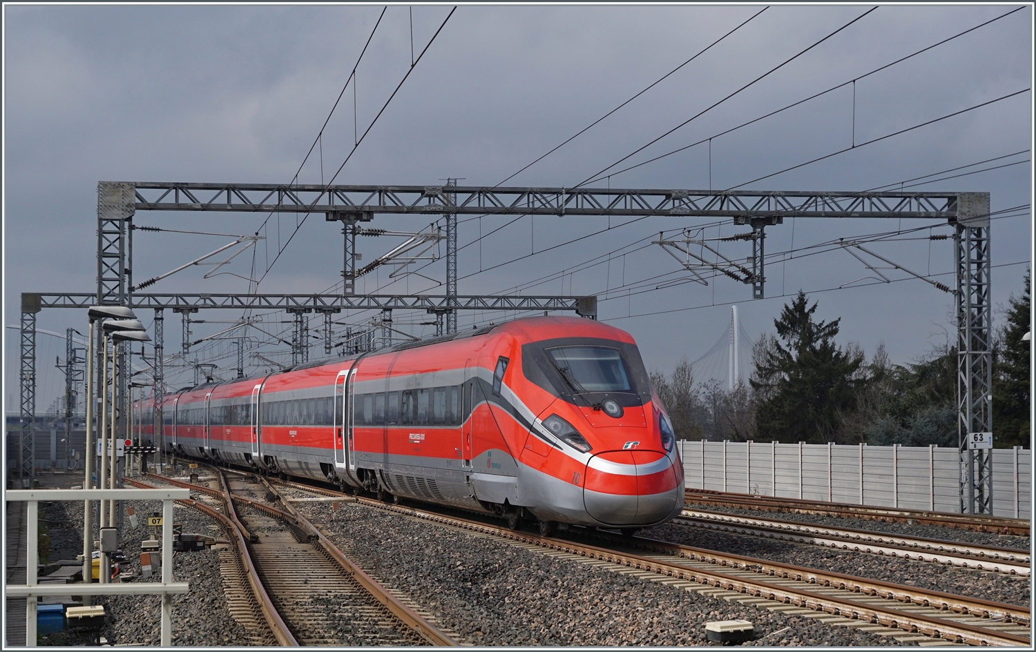 Der FS Trenitalia ETR 400 010 ist als FR9624 von Roma nach Milano unterwegs und fährt ohne Halt durch den Bahnhof von Reggio Emilia AV. 

14. März 2023