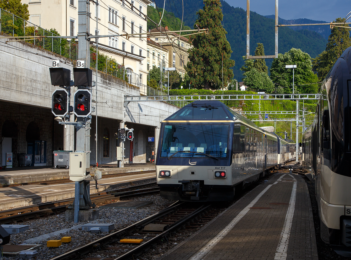 Der MOB GoldenPass-Zug R 2232 nach Zweisimmen verlässt am 26 Mai 2023 den Bahnhof Montreux, am Zugschluss der vierachsige MOB 1.Klasse Panorama-Steuerwagen Ast 117 (ex Arst 117).

Beflügelt durch den Erfolg des “Panoramic-Express” nahm die MOB 1986 eine dritte Komposition in Betrieb, welche aber gegenüber den beiden vorherigen nur die erste Wagenklasse führte und von zwei Panorama-Steuerwagen an beiden Zugenden gesteuert wurden. Die beiden Arst 116/117 erhielten dabei die Führerstände aus den dazwischen eingereihten Triebwagen BDe 3005/3006, welche ebenfalls farblich an den Zug angepasst wurden. Der Barwagen Ars 115 komplettierte den Paradezug der MOB. Ganze Frontseite steht den (VIP) Reisenden als Aussichtsabteil zur Verfügung. 

TECHNISCHE DATEN:
Hersteller: R&J / MOB / SIG
Spurweite: 1.000 mm (Meterspur)
Achsanzahl: 4 (in 2 Drehgestellen)
Länge über Puffer: 17.290 mm 
Wagenkastenlänge: 16.470mm
Höhe: 3.700 mm
Breite: 2.650 mm
Drehzapfenabstand: 11.350 mm 
Achsabstand im Drehgestell: 1.800 mm
Drehgestell Typ: SIG- Torsionsstab
Laufraddurchmesser: 750 mm (neu)
Eigengewicht: 20  t 
Höchstgeschwindigkeit: 100 km/h
Sitzplätze: 8 VIP-Plätze hinter der Frontscheibe und 25 in der 1. Klasse  
WC: 1

Quellen: x-rail.ch 