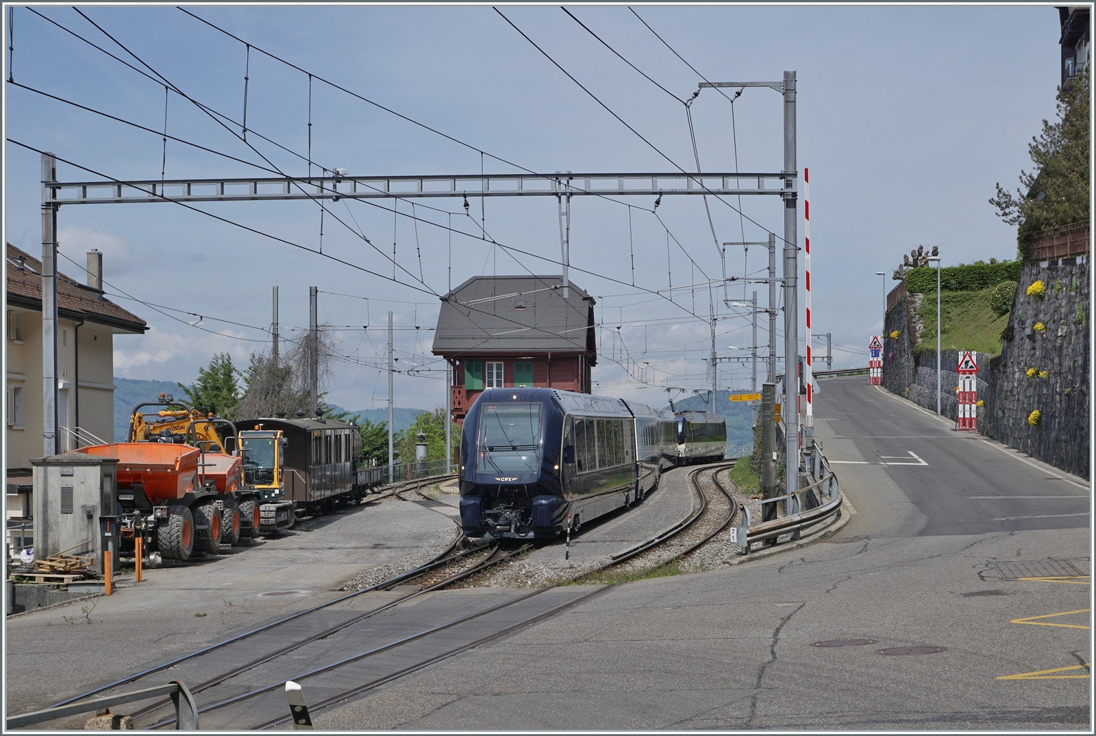 Der MOB GPX 4065 von Zweisimmen nach Montreux mit der schiebenden Ge 4/4 8004 muss in Chamby den Gegenzug abwarten. Obwohl der Zug infolge Problemen mit Normalspurweichen nur noch bis und ab Zweisimmen verkehrt, kommt er dank der Blonay-Chamby Bahn weiterhin in Sichtt-Kontakt mit der BOB, wie der links im Bild zu erkenne BOB Kaiserwagen. Das Bild entstand beim geöffneten Bahnübergang, siehe Barriere rechts im Bild. 

6. Mai 2023