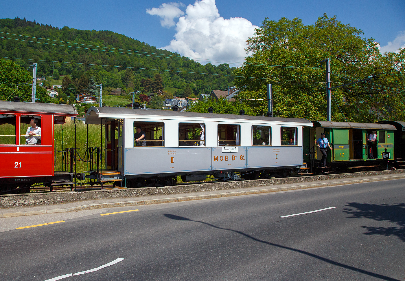 Der schmalspurige vierachsige zweite Klasse Personenwagen mit zwei Plattformen MOB B⁴ 61 seit 2016 als Geschenk von der Modellbahngruppe Obersimmental-Saanenland (MOS) bei der Museumsbahn Blonay–Chamby hier am 27 Mai 2023 im Zugverband eines BC Zuges in Blonay.

Der Wagen wurde 1906 SIG (Schweizerische Industriegesellschaft) in Neuhausen am Rheinfall als B⁴ 61 für die MOB (Montreux-Berner Oberland-Bahn) gebaut. 

Die beiden Wagen B⁴ 61 und B⁴ 62, die keine Toilette aufwiesen, wurden zusammen mit den Personenwagen BC⁴  23–26 beschafft. Grund war die Aufnahme des durchgehenden Betriebs auf der Strecke Montreux–Zweisimmen im Jahr 1905. Zudem wurden die Prognosen zur Zahl der Reisenden übertroffen. Nachdem die MOB anfänglich für die Reisezüge Drehgestell-Wagen beschafft hatte, folgten aus Kostengründen Zweiachser. Infolge von Reklamationen wechselte die MOB wiederum auf Drehgestell-Wagen, wobei es dann auch blieb.

Geschichte:
Ab 1901 in mehreren Etappen in Betrieb genommen, erreichte die Linie der Montreux-Berner Oberland (MOB) 1905 Zweisimmen. Neben der Erschließung durchquerte sie auch die bis dahin schwer zugänglichen Gebiete, insbesondere das kleine Dorf Gstaad. Das landwirtschaftliche Dorf verwandelt sich schnell in einen weltberühmten Bergkurort, es ermöglicht Touristen, die an der Waadtländer Riviera (der östlichen Teil des Nordufers des Genfersees) übernachten, direkt nach Spiez und dann nach Interlaken zu gelangen, ohne den Umweg über Bern zu machen, und gleichzeitig einen Ausflug inmitten außergewöhnlicher Panoramen zu genießen. Zudem war es damals wohl die schneller Strecke nach Spiez.

Zu diesem Zweck verband 1910 eine Expressverbindung mit Anschluss Zweisimmen Montreux in nur 4 Stunden über eine Strecke von 114 km mit Interlaken. Dieser als „Montreux-Simmenthal-Express“ bezeichnete Zug fuhr mit einem Speisewagen sowie mit Wagen der 1. Wagenklasse, was damals auf einer Nebenbahn sehr selten war. Insgesamt war das Rollmaterial von Anfang an mit einem hohen Maß an Komfort ausgestattet, wie der „B 61“, mit 30 Sitzplätzen (Polstersessel) in der 2. Klasse. Wie damals üblich war in allen Zügen auch eine dritte Klasse mit Holzbänken vorhanden; 1956 wurde das System auf europäischer Ebene mit 2 Klassen vereinheitlicht. Die bequemen historischen Polstersessel wurden dann 1956 durch Holzbänke ersetzt, dadurch hatte der Wagen nun 40 Sitzplätzen in der „neuen“ 2. Klasse. Der „B 61“ beendete seine „aktive“ Karriere bei der MOB Ende der 1979 im Regionalverkehr, insbesondere zwischen Montreux und Les Avants. Er wurde 1979 für 100 Franken an die MOS - Modellbahngruppe Obersimmental-Saanenland (MOS) verkauft. Die MOS nutzte ihn von 1979 bis 2015 als Vereinslokal in Saanen, zusammen mit dem 1995 übernommenen ursprünglichen MOB BFZe 4/4 26 und K 529. 2015 musste die Modellbahngruppe (heute aufgelöst) den Standort in Saanen infolge Sanierung der Bahnstrecke und des Bahnhofes aufgeben und verlegte diesen nach Zweisimmen. Sie schenkte in der Folge 2016 den Wagen B⁴ 61 (ohne Inneneinrichtung) der Museumsbahn Blonay–Chamby. Bei der BC wurde er komplett überholt und in den Originalzustand, einschließlich der bequemen historischen Polstersessel, versetzt. Am 10. Mai 2018, anlässlich des „Mega Steam Festival“ dem 50-jährigenJubiläums der BC wurde er in Dienst gestellt und präsentiert.	
TECHNISCHE DATEN:
Hersteller: SIG (1906) 
Spurweite: 1.000 mm (Meterspur)
Achsanzahl: 4 (in 2 Drehgestellen)
Länge über Puffer: 11.630 mm 
Länge Wagenkaten: 10.630
Höhe / Breite: 3.600 mm / 2.700 mm
Drehzapfenabstand: 6.500 mm 
Achsabstand im Drehgestellt: 1.200 mm
Drehgestelle Typ: SIG, einfache Federung
Laufraddurchmesser: 750 mm (neu)
Eigengewicht: 9.800 kg
Sitzplätze: 30 (40 mit Holzbänken von 1956 bis 1979)
Höchstgeschwindigkeit: 50 km/h
Kupplungen: Mittelpuffer mit einer Schraubenkupplungen (Zp 1)

Quellen: Museumsbahn BC, x-rail.ch und wikipedia
