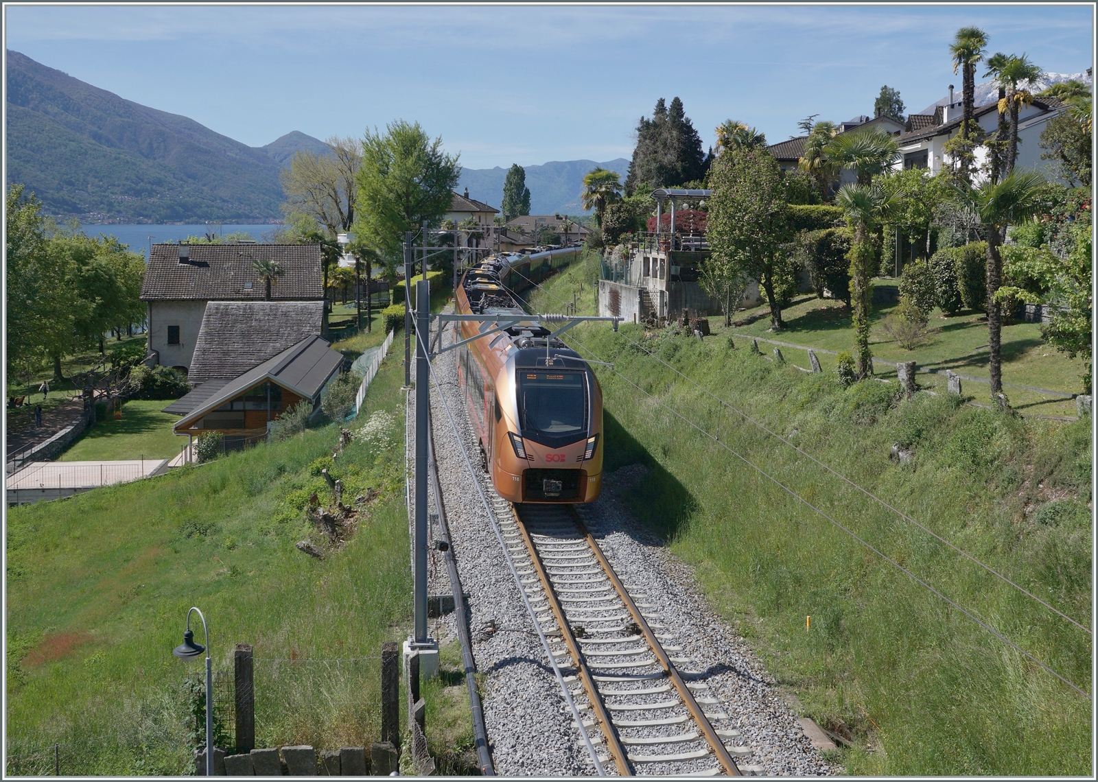 Der SOB RABe 526 118  Treno Gottardo  ist zwischen Locarno und Tenero als IR26 2324 nach Basel SBB unterwegs. Es ist eine der wenigen Stellen an der stark verbauten Strecke, wo mit etwas Geschick doch noch etwas Grün mit aufs Bild zu bekommen ist, selbst, wenn der nahe See nur andeutungsweise im Hintergrund zu erkennen ist.

26. April 2023