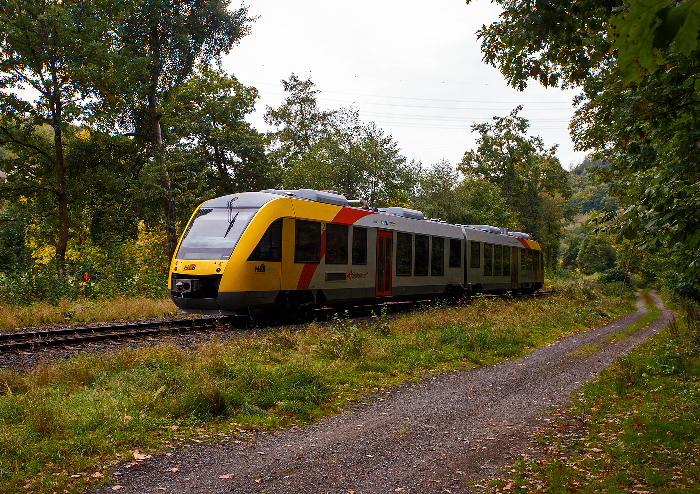 Der VT 258 (95 80 0648 158-3 D-HEB / 95 80 0648 658-2 D-HEB) ein Alstom Coradia LINT 41 der HLB (Hessische Landesbahn) erreicht am 03 Oktober 2025, als RB 96  Hellertalbahn  (Dillenburg – Haiger – Herdorf – Betzdorf/Sieg), bald den Hp Grünebach Ort. So langsam verfärben sich die ersten Blätter, es wird Herbst.

Der Alstom Coradia LINT 41 wurde 2004 von der ALSTOM Transport Deutschland GmbH (vormals LHB - Linke-Hofmann-Busch GmbH) in Salzgitter-Watenstedt unter der Fabriknummer 1188-008 für die vectus Verkehrsgesellschaft mbH gebaut, mit dem Fahrplanwechsel am 14.12.2014 wurden alle Fahrzeuge der vectus nun Eigentum der HLB, die Hessische Landesbahn hatte 74,9% der Gesellschaftsanteile.
