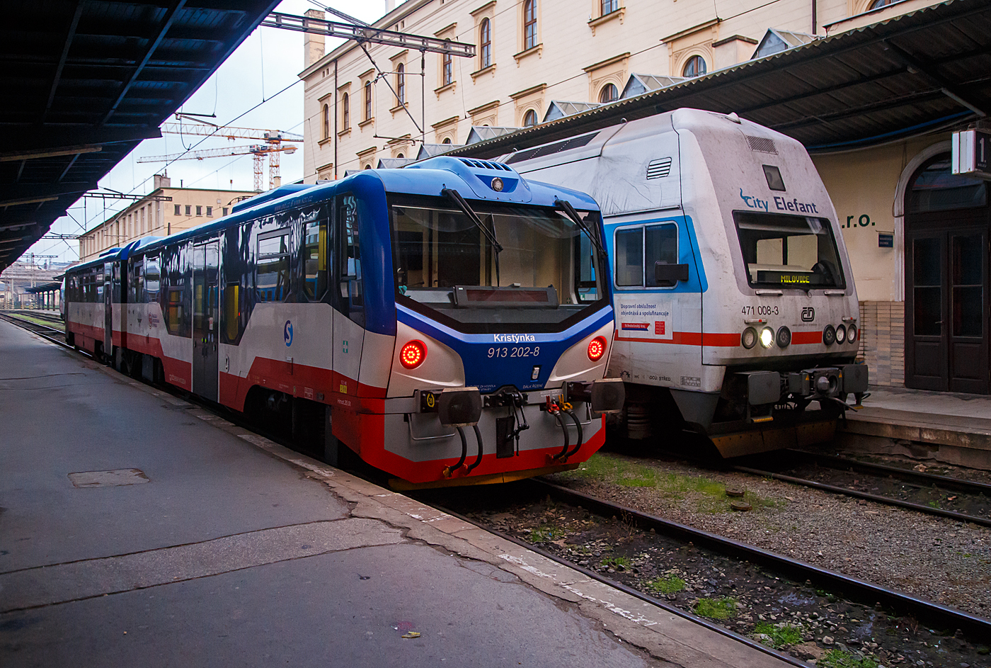 Der VT 813 202-9  / 913 202-8 „Kristnka“ (Christine) (CZ-KC 95 54 5 813 202-9 / CZ-KC 95 54 5 913 202-8) der KC Doprava (Klub elezničnch cestovatelů) steht am 23.11.2022, als S 34 Praha Masarykovo ndra – Praha-Čakovice fr die S-Bahn Prag (Esko Praha), im Bahnhof Praha Masarykovo ndra (Prag Masarykbahnhof). 

Der VT 813 202 entstand, 2018 bei  OS in Zvolen (Slowakei) auf Basis der slowakischen BR 813.1, aus den Fahrzeugen 810-499 und 011-896 und erhielt den Namen Kristnka (Christine) nach der jngeren Tochter des Besitzers der KC Doprava, die Inbetriebnahme erfolgte im Februar 2019. 

Als Weiterentwicklung der zwischen 2007 und 2009 umgebauten 29 Triebwagen der Reihe 813.0 wurden im Jahr 2014 auf Bestellung von ZSSK ein Auftrag zum Neubau von acht Doppeleinheiten der neuen Reihe 813.1 in Auftrag gegeben. Sie entstanden aus 16 abgestellten Triebwagen der Reihe 810 bzw. Beiwagen der  Reihe 010 (ex Btax780). Die Entwicklung und Fertigung wurde an OS Zvolen in Auftrag gegeben. Zunchst entstand 2014 eine mit 813 110 (Triebwagen) und 913 110 (Steuerwagen) bezeichnete Einheit, welche noch im gleichen Jahr von der ZSSK ausgiebig getestet wurde. Bis Ende 2017 wurden alle acht Einheiten an die ZSSK geliefert und als 813 111+913 111 bis 813 117+913 117 bezeichnet. Diese Einheiten waren bei der ZSSK die ersten Wagen der 813er Reihe mit Niederflurbereich und geschlossenem Toilettensystem. Auerdem boten sie fr das Personal wesentliche Erleichterungen. Gegenber den Vorgngerfahrzeugen besaen sie eine vllig neu gestaltete uere Form. Die Fahrzeuge befinden sich im direkten Vergleich mit den Vorgngerfahrzeugen der BR 810. Die im Aussehen so gut wie identische Nachfolgebauart ZSSK-Baureihe 813.2 wurde bereits im gleichen Jahr mit weiteren Verbesserungen ausgeliefert, es sind zwei Einheiten bekannt, die seither bei dem Verein KC Doprava in Tschechien verkehren.

Die KC Doprava beauftragte 2017 OS in Zvolen (Slowakei) mit der Herstellung von zwei neuen Verbrennungstriebwagen auf Basis der o.g. slowakischen BR 813.1, die zuvor von SSK bestellt wurden. Die Triebwagen der BR 813.2 wurde erheblichen nderungen und Verbesserungen unterzogen und bertraf die der ČD BR 814 (RegioNova) in vielen betrieblichen sowie technischen, technologischen und sthetischen Aspekten definitiv. Die Verbrennungstriebwagen sind niederflurig und erfllen die hohen Anforderungen der PNV-Kunden an Qualitt und Standards. Die Fahrzeuge werden auf der Stadtlinie S 34 in Prag betrieben.

Es handelt sich um die modernsten Fahrzeuge der tschechischen Eisenbahn, die auch im Jahr 2020 nicht durch die Lieferung anderer, modernerer Fahrzeuge bertroffen wurden. Die Inbetriebnahme mit der Baureihe 813.2 erfolgte im Februar 2019. Die VT sind zuverlssig und bei Reisenden beliebt. 

Triebwagen haben einen Dieselmotor vom Typ TEDOM TD 310 RH TA 26 mit einer Leistung von 310 kW (bei einer Nenndrehzahl von1.950 U/min), die Kraftbertragung erfolgt ber ein hydromechanisches vierstufiges automatisches VOITH DIWA D 884,5 Getriebe, auf das mechanische Achsgetriebe von GMEINDER GGM 190 (265 kW). Die Bremse ist ein DAKO-System mit DAKO-BSE-Elektrobremsen, das Steuersystem ist MIREL 813. Die Motoreinheit hat Klappfenster, die aber in der Grundstellung verriegelt sind, da das Fahrzeug vollklimatisiert ist. Die Hchstgeschwindigkeit des Triebzuges betrgt 90 km/h.

TECHNISCHE DATEN der BR 813.2/913.2 (zweiteilig / Duo):
Hersteller: BR 810 Vagnka Studnka  (heute koda Vagonka a.s.) 
Umbau: OS Zvolen (Slowakei)
Spurweite: 1.435 mm (Normalspur)
Achsformel: 1'A' + 1'1
Lnge ber Puffer: 28.820 mm
Achsabstnde: 8.000 / 6.850 / 8.000 mm
Leergewicht: 41.910 kg 
Dienstgewicht: 56,2 t
Radsatzfahrmasse: 14 t
Dieselmotortyp: TEDOM TD 310 RH TA 26
Installierte Leistung: 310 kW (421 PS) bei 1.950 U/min
Getriebe: vierstufiges automatisches VOITH DIWA D 884,5
Leistungsbertragung: hydromechanisch
Achsgetriebe: mechanisches GMEINDER GGM 190 (265 kW).
Anfahrzugkraft: 
Hchstgeschwindigkeit: 90 km/h
Sitzpltze: 63 und 2 Klappsitze
Stehpltze: 111
Fubodenhhe:  580 mm (Niederflurteil)

Quellen: KC, OS, Wikipedia
