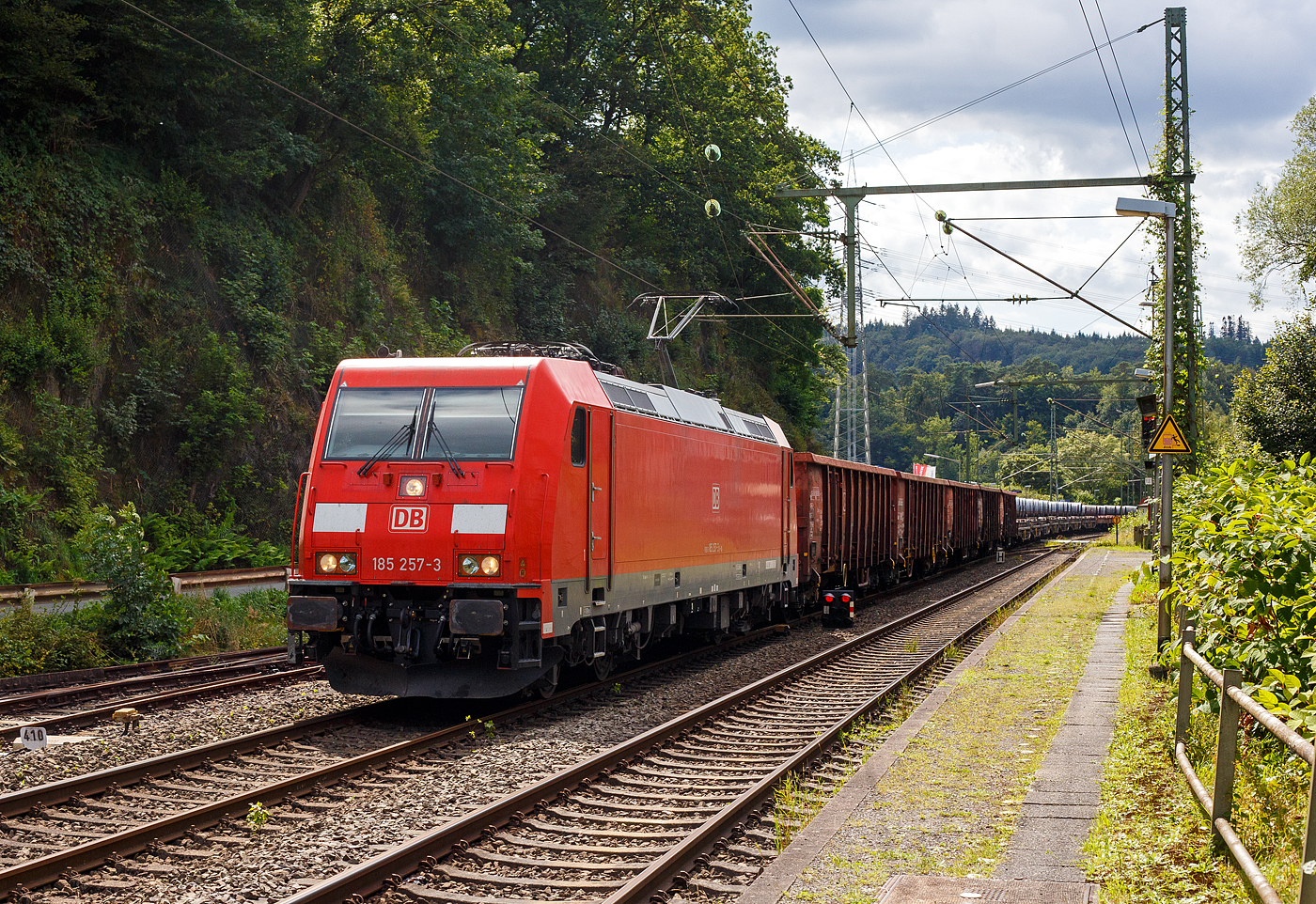 Die 185 257-3 (91 80 6185 257-3 D-DB) der DB Cargo AG fährt am 08 August 2024 mit einem gemischten Güterzug (vier Wagen der Gattung Eaons-x 059, sowie sechsachsige Coilwagen der Gattung Sahmms) durch Scheuerfeld (Sieg) in Richtung Siegen bzw. Kreuztal.

Die TRAXX F140 AC2 wurde 2006 bei Bombardier in Kassel unter der Fabriknummer 34104 gebaut. Sie hat die Zulassungen für Deutschland und Österreich.
