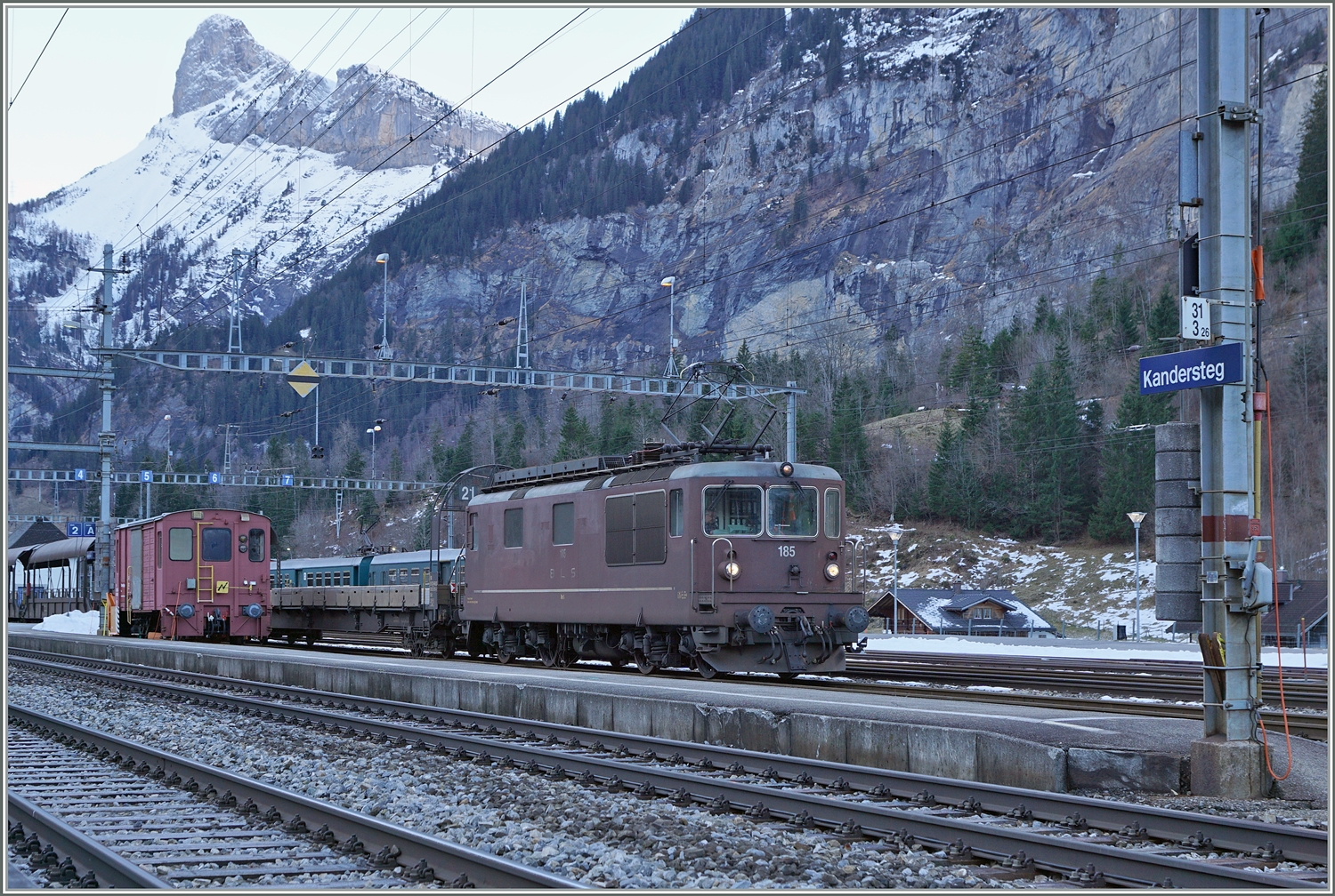 Die Autotunnelzüge der Strecke AT1 (und AT2 in der Hochsaiseon) nach Kandersteg (bzw. Iselle) sind im Bahnhof von Kandersteg fotografisch gesehen an einer sehr ungeschickt Stelle zu finden und somit kaum fotografier bar. Die Strecke bis zum Tunnel bietet jedoch gute Möglichkeiten, die letzten im Einsatz befindlichen BLS Re 4/4 zu fotografieren. Ich blieb trotzdem an Bahnhof von Kandersteg und konnte die BLS Re 4/4 185 mit ihrem Autotunnelzug im Bahnhof fotografieren. Der Zug wartet auf die Abfahrt des BLS RABe 521 als R1 von Domodossola nach Bern, um dann als Dienstzug in Richtung Frutigen zu fahren.

3. Jan. 2024 