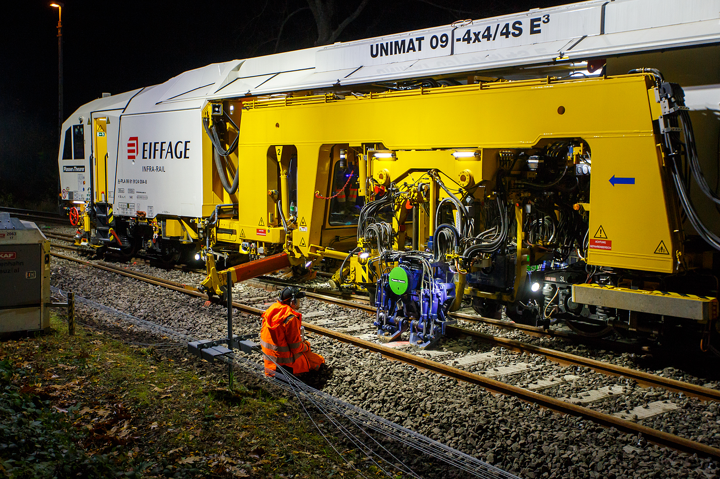 Die Baustelle Bahnhof Herdorf am Abend des 26 Oktober 2025, nun ab 20:40 Uhr wird die neue Weiche 3, beim Bahnhof/Stellwerk Herdorf Fahrdienstleiter (Hf), gestopft. Hier kam die recht neue Plasser & Theurer UNIMAT 09-4x4/4S E³ (A-PLA 99 81 9124 004-8), eine Universal-Weichenstopfmaschine mit Hybrid-Antriebstechnik, der Firma Eiffage Infra-Rail GmbH (Herne) zum Einsatz. Ob die Maschine nur von Eiffage Infra-Rail gemietet oder nun gekaut wurde ist mir nicht klar, aber eingestellt ist sie in Österreich über Franz Plasser Vermietung von Bahnbaumaschinen GmbH.
Detailbild vom Stopfvorgang, hier kann am auch gut erkennen was u.a. eine Weichenstopfmaschine ausmacht, die Stopfpickel sind u.a. seitlich verschiebbar.  Die Baustelle Bahnhof Herdorf am Abend des 26 Oktober 2025, nun ab 20:40 Uhr wird die neue Weiche 3, beim Bahnhof/Stellwerk Herdorf Fahrdienstleiter (Hf), gestopft. Hier kam die recht neue Plasser & Theurer UNIMAT 09-4x4/4S E³ (A-PLA 99 81 9124 004-8), eine Universal-Weichenstopfmaschine mit Hybrid-Antriebstechnik, der Firma Eiffage Infra-Rail GmbH (Herne) zum Einsatz. Ob die Maschine nur von Eiffage Infra-Rail gemietet oder nun gekaut wurde ist mir nicht klar, aber eingestellt ist sie in Österreich über Franz Plasser Vermietung von Bahnbaumaschinen GmbH.
Detailbild vom Stopfvorgang, hier kann am auch gut erkennen was u.a. eine Weichenstopfmaschine ausmacht, die Stopfpickel sind u.a. seitlich verschiebbar.