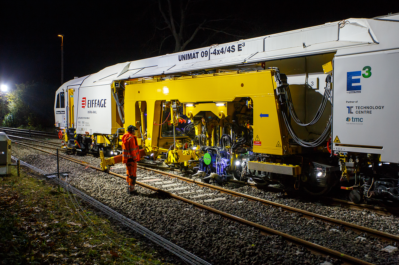 Die Baustelle Bahnhof Herdorf am Abend des 26 Oktober 2025, nun ab 20:40 Uhr wird die neue Weiche 3, beim Bahnhof/Stellwerk Herdorf Fahrdienstleiter (Hf), gestopft. Hier kam die recht neue Plasser & Theurer UNIMAT 09-4x4/4S E³ (A-PLA 99 81 9124 004-8), eine Universal-Weichenstopfmaschine mit Hybrid-Antriebstechnik, der Firma Eiffage Infra-Rail GmbH (Herne) zum Einsatz. Ob die Maschine nur von Eiffage Infra-Rail gemietet oder nun gekaut wurde ist mir nicht klar, aber eingestellt ist sie in Österreich über Franz Plasser Vermietung von Bahnbaumaschinen GmbH.
Detailbild vom Stopfvorgang, hier kann am auch gut erkennen was u.a. eine Weichenstopfmaschine ausmacht, die Stopfpickel sind u.a. einzeln wegschwenkbar.  Die Baustelle Bahnhof Herdorf am Abend des 26 Oktober 2025, nun ab 20:40 Uhr wird die neue Weiche 3, beim Bahnhof/Stellwerk Herdorf Fahrdienstleiter (Hf), gestopft. Hier kam die recht neue Plasser & Theurer UNIMAT 09-4x4/4S E³ (A-PLA 99 81 9124 004-8), eine Universal-Weichenstopfmaschine mit Hybrid-Antriebstechnik, der Firma Eiffage Infra-Rail GmbH (Herne) zum Einsatz. Ob die Maschine nur von Eiffage Infra-Rail gemietet oder nun gekaut wurde ist mir nicht klar, aber eingestellt ist sie in Österreich über Franz Plasser Vermietung von Bahnbaumaschinen GmbH.
Detailbild vom Stopfvorgang, hier kann am auch gut erkennen was u.a. eine Weichenstopfmaschine ausmacht, die Stopfpickel sind u.a. einzeln wegschwenkbar.
