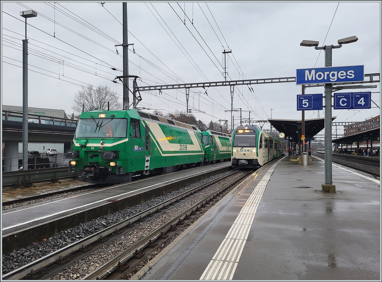 Die beiden BAM MBC Ge 4/4 22 und 21 warten in Morges mit ihrem Güterzug nach Apples auf die Abfahrt.
Rechts im Bild steht der Regio R 76 nach Bière.  
22. Feb. 2024 