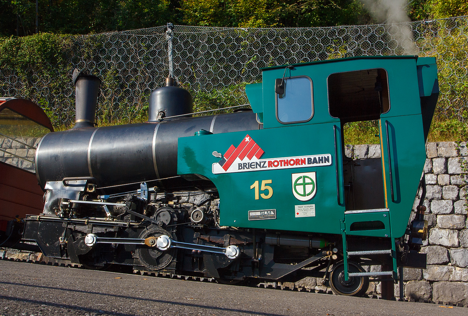 Die Heizöl befeuerte H 2/3 Zahnraddampflok BRB 15 Stadt Kanaya (Japan) am 30.09.2011 im BRB Bahnhof Brienz. 

Die Lok der 3. Generation wurde 1996 bei der Schweizerische Lokomotiv- und Maschinenfabrik, Winterthur (SLM, heute DLM AG) unter der Fabrik-Nr. 5690 gebaut. 

Eine wirklich moderne Dampflokomotive, durch die Befeuerungsart entfällt der zweite Mann, der Heizer, auf der Maschine.

Nachdem die BRB anfing, die vorhandenen Dampfloks durch Dieselloks zu ersetzen, gingen die Fahrgastzahlen zurück, weil Touristikbahnen, wie die BRB, mit dampfgetriebenen Loks beliebter waren. Deshalb bestellte die BRB 1989 zusammen mit der Chemin de fer Montreux–Territet–Glion–Rochers-de-Naye (MTGN) und der ÖBB, welche den Fuhrpark ihrer beiden meterspurigen Zahnradbahnen, der Schafbergbahn und der Schneebergbahn erneuern wollte, bei der Schweizerischen Lokomotiv- und Maschinenfabrik (SLM) drei ölgefeuerte Neubau-Dampfloks. 1992 wurden die drei Loks unter den Fabriknummern 5424 (ÖBB 999.201), 5456 (BRB 12) und 5457 (MTGN 1) geliefert. Aufgrund der Erfahrungen mit den Loks bestellte die ÖBB weitere drei Loks und die BRB zwei Stück. Diese wurden 1995/96 unter den Fabriknummer 5686–5690 (ÖBB 999.202–204, BRB 14–15) geliefert. Da die MTGN-Lok nur für vereinzelte Dampffahrten verwendet wurde, wurde sie schliesslich 2005 an die BRB verkauft, wo sie die Nummer 16 erhielt. Die Nummer 13 wird bei der BRB nicht besetzt.

Technische Daten: 
Spurweite: 800 mm
Zahnstange System: Abt
Leistung: 300 kW (408  PS) 
Zugkraft: 70 kN 
Leergewicht: 13.200 kg
Dienstgewicht: 15.700kg 
Länge über Puffer: 6.260 mm
Breite: 2.200 mm
Höhe: 3.200 mm
Achsfolge: 2zz1' (d.h. 2 nicht angetriebene Tragachsen, 2 Triebzahnräder, 1 bewegliche Laufachse)
Zahnradübersetzung:  1 : 2.3 
Heizölvorrat im Tank: 560 Liter
Wasser im Kessel: 1.200 l
Wasservorrat im Kasten: 1.400l
Verbrauch pro Fahrt Brienz-Rothorn und retour:
Heizölbedarf: 150 l
Wasserbedarf: 2.000 l
Höchstgeschwindigkeit bei 250 ‰: 12 km/h
max. Vorstelllast  bei 250 ‰: 17.000 kg 
max. Kesselüberdruck: 16 bar
max. Überhitzung: 420° C

Keine Feuerung bei Talfahrt: ergeben gute Durchschnittswerte für Abgase. Bei Talfahrt wird die Dampfmaschine als Luftpumpe betrieben, sie bremst den gesamten Zug, zur Kühlung muss Wasser eingespritzt werden.
Gegendruckbremse System Riggenbach
Druckluftbetätigte Federspeicherbremse
Handspindelbetätigte Bandbremse
Elektronische Sicherheits- und Notbremssteuerung
Rückrollsicherung
    
Beschaffungskosten (1996): 2.100.000,00 CHF