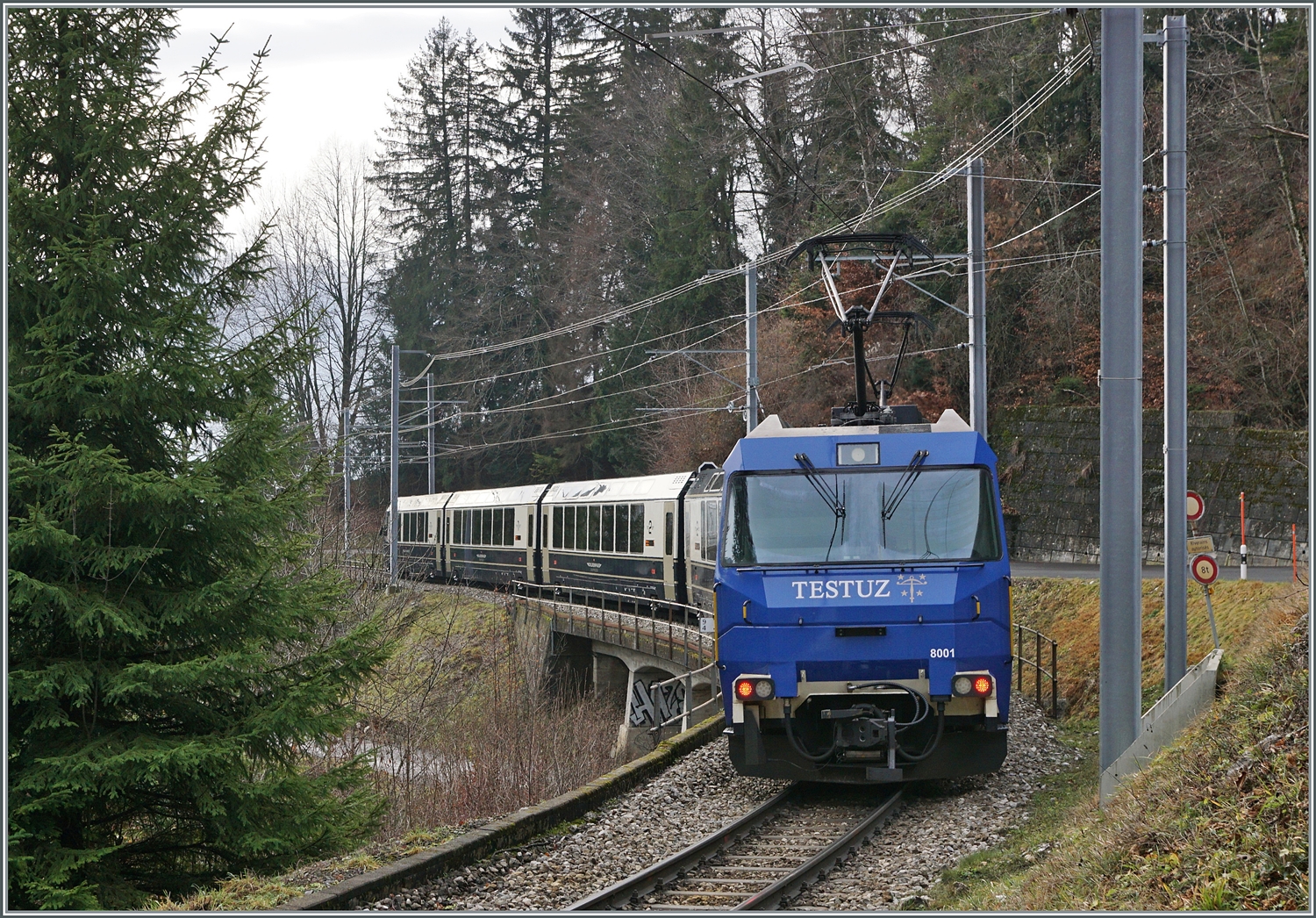 Die MOB Ge 4/4 8001 ist als Schublok mit dem GoldenPass Express 4065 von Interlaken nach Montreux unterwegs. Die Ge 4/4 8001 hat den Zug in Zweisimmen übernommen und rollt nun kurz nach der 93 Meter langen Pont Gardiol, welche den Bois des Chenaux überbrückt, ihrem Ziel Montreux entgegen. 

4. Januar 2023