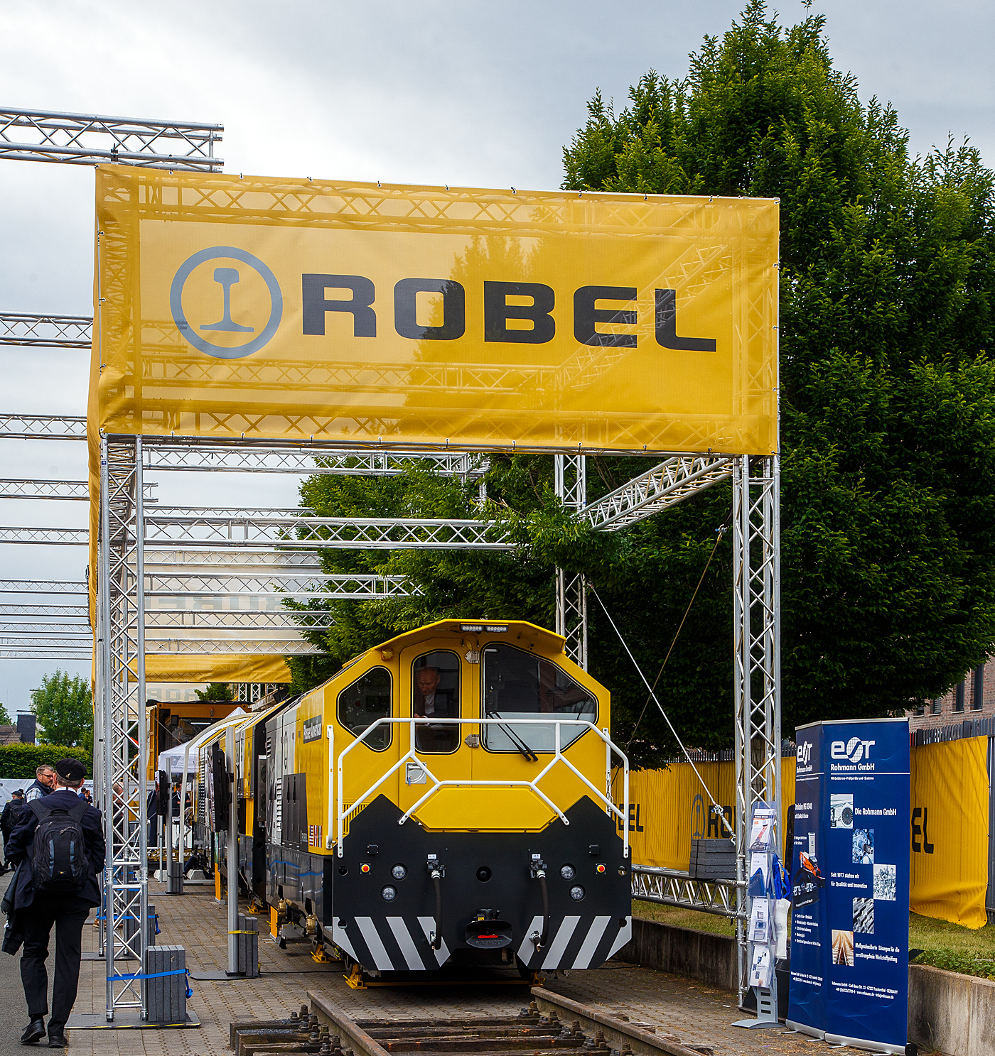 Die Robel Bahnbaumaschinen GmbH aus Freilassing (gehrt zu Plasser & Theurer) prsentierte auf der 28. Internationale Ausstellung Fahrwegtechnik (iaf) in Mnster (hier am 31.05.2022) das dreiteilige Schienenbearbeitungssystem ROMILL Urban 3 E fr die Plasser American Corporation (PAC) mit Sitz in Chesapeake, Virginia. Die Lieferung soll im Sommer 2022 erfolgen. Das Schienenbearbeitungssystem ROMILL Urban E ist ein gemeinsames Projekt von Robel, Schweerbau International GmbH & Co.KG (SBI) und Vogel & Pltscher GmbH & Co.KG, es ist die weltweit erste Hybrid-Frsmaschine von Robel. Die Firmen Schweerbau und SBI gehren auch zur Robel Holding GmbH, ex Deutsche Plasser Holding GmbH.

Fahrzeugdesign, Antriebs -und Frstechnologien der Romill Urban E wurden von SBI speziell fr die U-Bahn Instandhaltung entwickelt. Die drei Einheiten sind fr sehr kleine Lichtraumprofile, beispielsweise die der London Underground, ausgelegt und knnen somit in beinahe allen nordamerikanischen Tunneln eingesetzt werden. Der Hybrid-Antrieb, eine Kombination aus Batteriespeicher und Range-Extender ber einen abgasreduzierten Dieselmotor, ermglicht emissionsfreie Schienenbearbeitung. Der Hybridantrieb ermglicht mit seiner Hochleistungsbatterie bis zu 3 Stunden emissionsfreien Betrieb (kein CO, CO2 oder NOx etc.). Darber hinaus fungiert der integrierte Tier-4-F-Dieselmotor als Range Extender und bietet Schnellladefhigkeiten.

Romill Urban E ist mit einer neuen, rein elektrischen Frstechnologie ausgestattet, die erstmals auch die Bearbeitung von Gleisen mit geringer Gleislagequalitt erlaubt. Die Reprofilierung der Schiene erfolgt staub- und funkenfrei mit vollstndigem Recycling der Spne. Zur Erzeugung einer lrmoptimierten Schienenlaufflche kommt zustzlich ein Hochgeschwindigkeits-Polierprozess zur Anwendung. Das revolutionre neue Schneidkopfdesign fhrt zu einer lngeren Werkzeuglebensdauer und ermglicht erweiterte Einsatzmglichkeiten ohne Werkzeugwechsel. Die Maschine ist mit modernster Messtechnik ausgestattet, darunter Metallabtrag, Querprofil, Lngsprofil und Wirbelstromsystem. Durch die modulare Konfiguration ist zur Leistungssteigerung 4-teilige Einheit mglich.

Durch das kompakte Layout der Frsmaschine passt sie die engsten U-Bahn-Tunnel. Sein ergonomisches dreiteiliges Maschinendesign ermglicht eine schnelle De-/Remontage und einen einfachen LKW-Transport zwischen den Einsatzorten.

TECHNISCHE DATEN:
Fahrzeuglnge: 23.000 mm
Breite: 2.350 mm
Hhe: 2.850 mm
Anzahl der Achsen: 6 (3 Wagen mit je 2 Achen)
Gewicht: 77,5 t
Max. Achslast: 13,3 t
Hchstgeschwindigkeit bei Eigenfahrt: 60 km/h (37 mph)
Min. Kurvenradius im Fahrbetrieb: R 30 m (164 ft)
Min. Kurvenradius im Arbeitsbetrieb: R 50 m (99 ft)
Minimalradien fr Bearbeitung: 50 m
Minimalradien fr Fahrten: 50 m
Hauptmotor :Diesel eu stage V
Optionaler Antrieb: Akku
Vorschub: 300 – 1200 m/h
Abtrag je berfahrt: 0,1 – 1,5 mm

Quellen: Robel, Plasser American