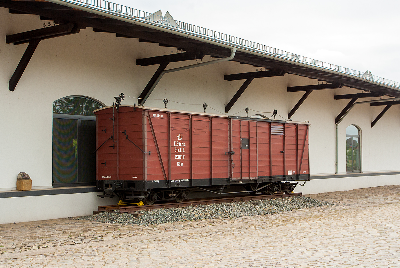 Ehemaliger K.Schs.Sts.E.B. vierachsiger gedeckter Gterwagen 2361K mit Heberleinbremse, der Gattung GGw, des Traditionsbahn Radebeul e.V., ausgestellt beim Schmalspur-Bahnhof Radebeul Ost (Lnitzgrundbahn), hier am 27.08.2013.

Der Wagen wurde 1918 von der Waggonfabrik Werdau gebaut und an die Kniglich Schsische Staatseisenbahnen (K.Schs.Sts.E.B.) geliefert. Bis 1974 war er bei der DR (Deutsche Reichsbahn) als DR GGw 97-13-06 im Radebeuler Planbestand, danach wurde er ausgemustert, seit 2000 ist er Eigentum des Vereins Traditionsbahn Radebeul.

TECHNISCHE DATEN:
Spurweite: 750 mm
Anzahl der Achsen: 4 (in 2 Drehgestellen)
Leergewicht: 7.360 kg
Ladegewicht: 10.000 kg
Ladeflche: 18,1 m
