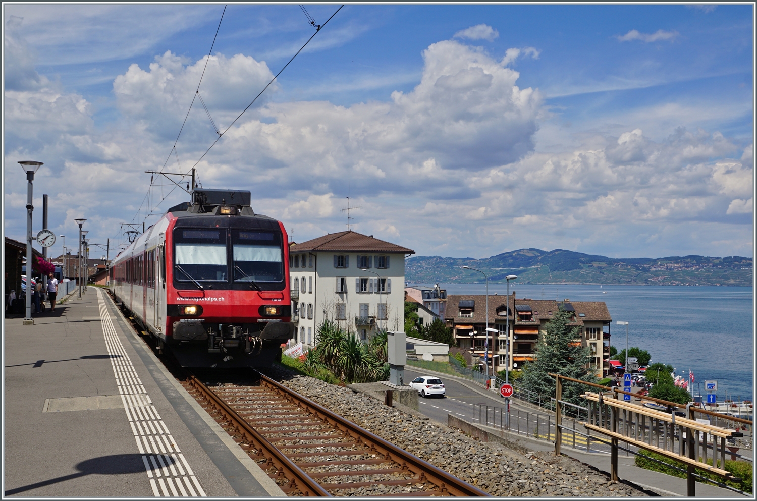 Ein Region Alps RBDe 560  Domino  wartet in St-Gingolph auf die Rückfahrt nach Brig. Im Hintergrund gleitet der Blick über den Genfersee bis zum Jura. 

30. Juli 2022