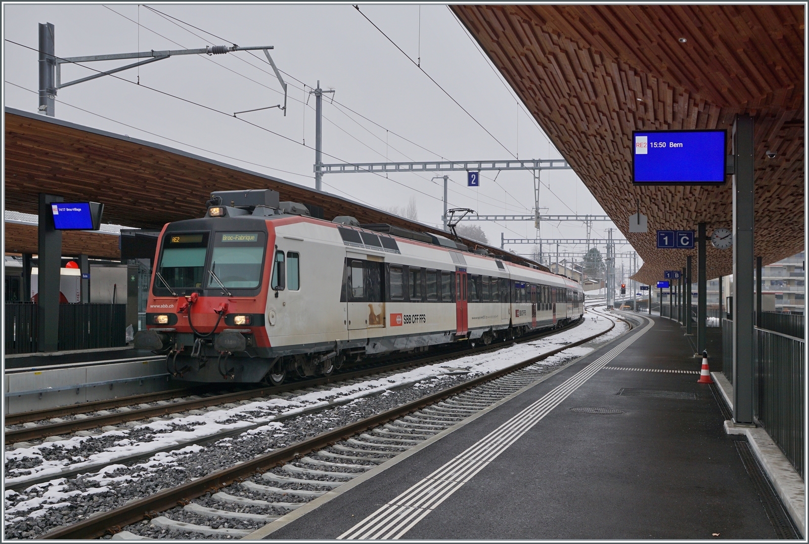 Ein SBB RBDe 560 wartet in Bulle auf die Abfahrt nach Broc. Beachtenswert die eindrücklche Bahnstigdachunterseite! 
Und - fährt der Zug nach Broc FABRIQUE (wie auf dem Zug vermerkt) oder nach Broc VILLAGE (wie auf dem Bahnsteig angekündigt? 
Die Antwort ist auf dem folgenden Bild zu sehen...

15. Dezember 2022