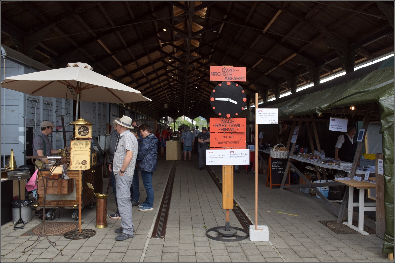 Fahrtag im Zürcher Oberland. 

Blick in die alte Basler Bahnhofshalle mit einem hübsch aufgemachten Kaffeestand am Eingang. Bauma, Juli 2023.
