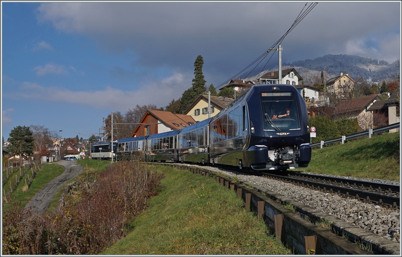 GPX - Goldenpass Express ein Traum in endlich in Erfüllung gegangen Umsteigefrei kann man nun von Montreux nach Interlaken Ost reisen. Zur Zeit verkehrt erst ein Zugspaar pro Tag und dies mit zwei Kompositionen, Montreux ab 9:35 und Interlaken ab 9:08; dies erlaubt wohl, sich an das neue Spurwechsel-System zu gewöhnen, führt aber Personal- und Material bedingt zu einer recht teuren Betriebsführung. Auch finde ich, sollte die neue Spurwechseltechnik für weitere Direktverbindung genutzt werden wie z.B Monterux - Bern, Bern - Lenk im Simmental, Zürich Flughafen - Davos etc. So ist dies eben mit den Träumen: Kaum erfüllt sich einer, gibt es eine Menge weiterer die geträumte werden wollen... Das Bild zeigt den allersten fahrplanmässigen GPX GoldenPass Express 4065, der Interlaken Ost um 9:08 verlassen hat und nun nach alter MOB Tradition bei Planchamp etwas dem Fahrplan hinterherhechelt. An der Spitze der Zuges ein neuer GPX Steuerwagen, am Zugschluss schiebt die Ge 4/4 8002.

11. Dezember 2022