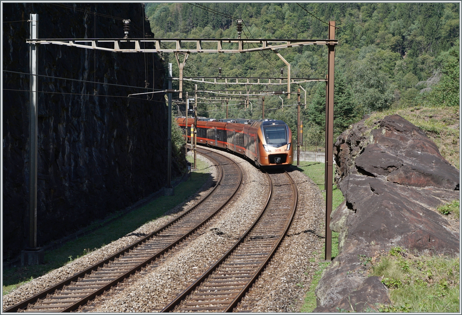 Im Juli 2016 fand ich eine Fotostelle nördlich von Faido, etwas oberhalb des Broscerinatunnel mit Blick auf die 103 Meter lange Polmengobrücke. Als ich die Fotostelle dieses Jahr erneut aufsuchte, ging ich einen Schritt weiter, genauer gesagt, bis zu einem verlassen  Wärterhaus  kurz vor dem oberen Portal des 1567 Meter langen Pratotunnel, der als 360 ° Kreiskehrtunnel gut 40 Meter Höhenunterschied überwindet. Das Bild zeigt einen RABe 526 als  Treno Gotthardo  auf dem Weg nach Locarno und unmittelbar hinter meinem Rücken den Prato Kreiskehrtunnel erreichen wird. Den SOB RABe 526 konnte ich gut zwei Minuten später auf der Polmengobrücke erneut fotografieren (siehe Bild ID 826493). Gerade solche Erlebnisse machen den Reiz der Gotthardbahn aus.

4. September 2023