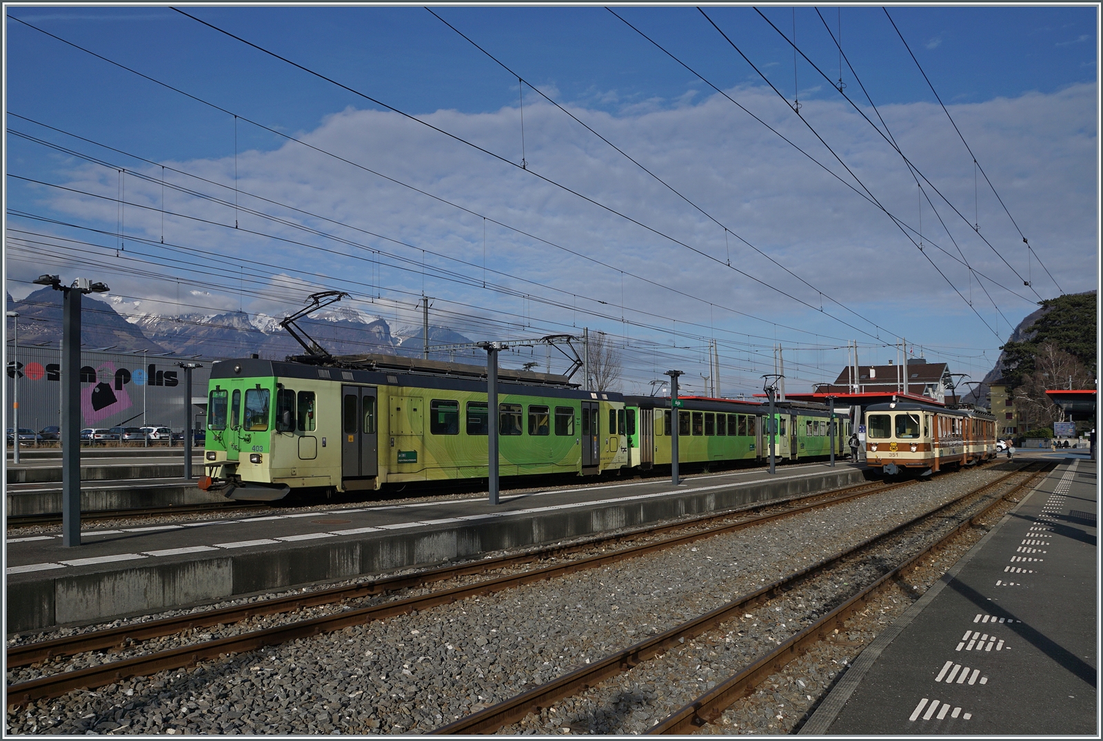 In Aigle wartet der TPC ASD BDe 4/4 403 mit Bt (ex BLT) und einem weitern BDe 4/4 auf die nächste Fahrt nach Les Diablerets, während im Hintergrund der letzte noch in A-L Farben gehaltene Pendelzug steht. 

17. Feb. 2024