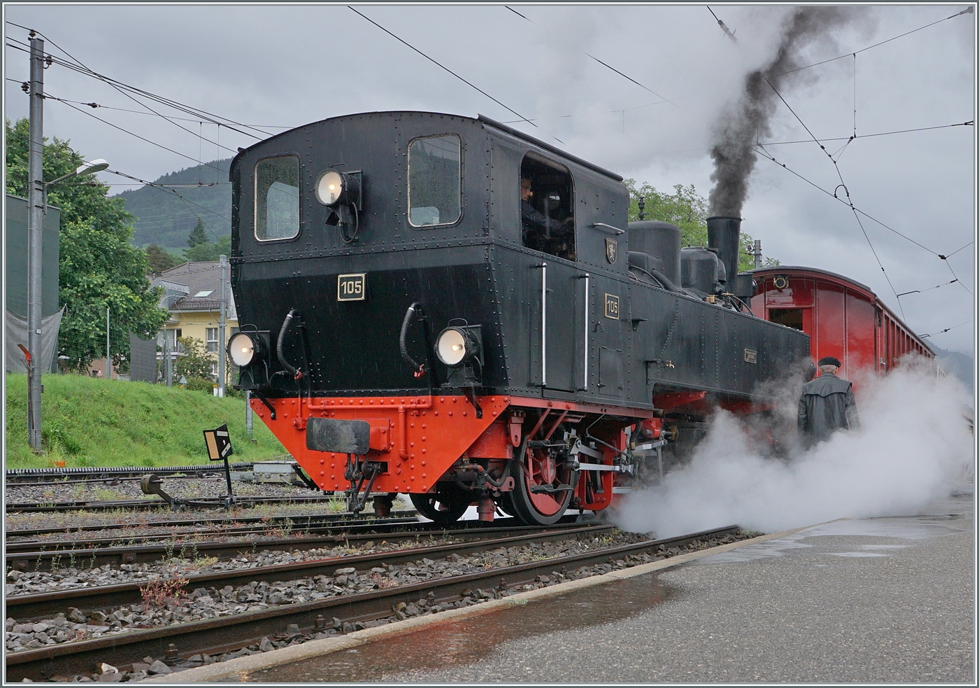 Kräftig dampfend verlässt die abgekuppelte SEG G 2x 2/2 105 der Blonay Chamby Bahn in Blonay ihren Zug, um ihn zu umfahren.
Gerade  schlechtes Wetter  bietet oft ganz besondere Motive, so dass sich eine Museumsbahnbesuch auch bei Regen lohnt. 

22. Juni 2024