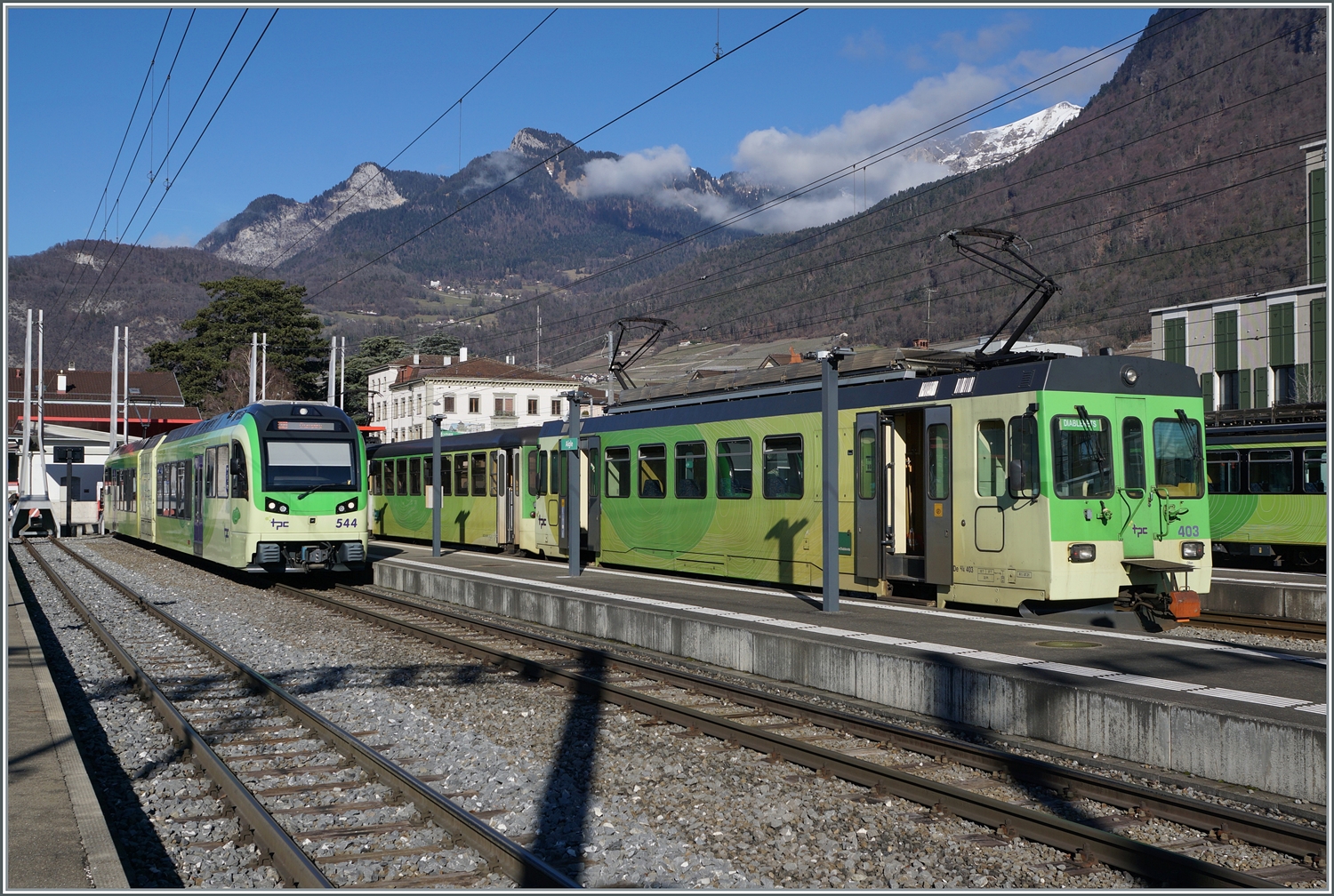 Links wartet der TPC AOMC/ASD Bhe 2/6 544 als R 72 in Richtung Monthey auf die Abfahrt und daneben der ASD Regionalzug (R71) mit dem führenden BDe 4/4 403. 

17. Feb. 2024