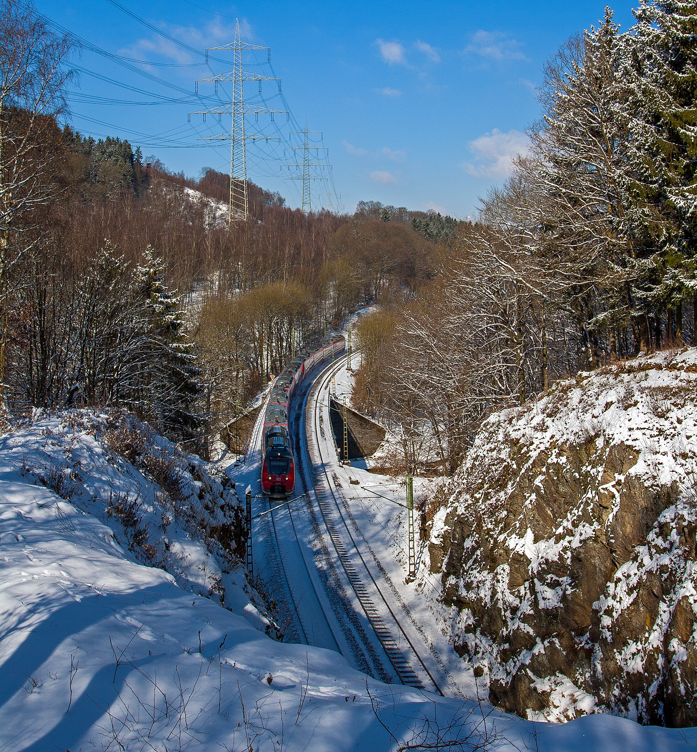 Mitte März 2013 lag sogar an der Sieg noch Schnee...
Zwei gekuppelte Bombardier Talent 2 (fünf- und vierteilig / BR 442/443) fahren am 13 März 2013 als RE 9 - Rhein Sieg Express (RSX) Aachen - Köln – Siegen und überquerem hier bei Scheuerfeld/Sieg kurz vor dem 32 m langen Mühlburg-Tunnel die Sieg. Da hier die Sieg eine Schleife macht, so geht es gleich hinter dem Tunnel wieder die Sieg. Nächster Halt ist dann Betzdorf/Sieg.