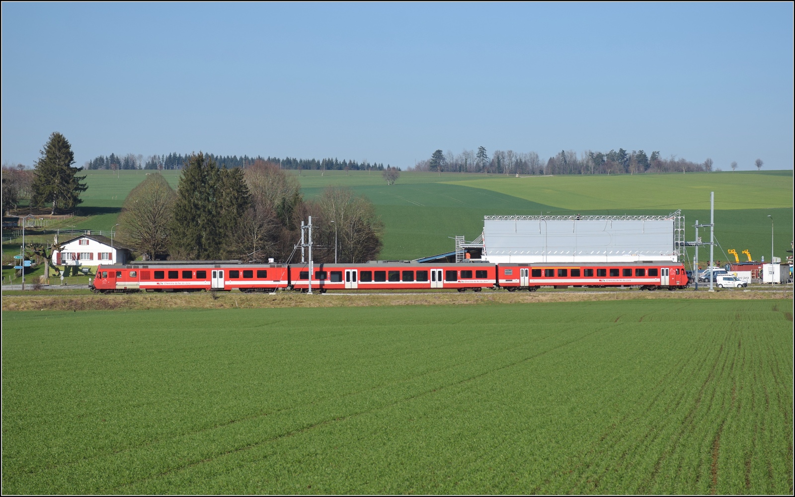 Noch ein bisschen Ajoie.

RABe 567 184 der CJ fhrt an der Kulisse von Alle vorbei, wie man sieht, ist die neue, hssliche Kltzchenbauweise nunmehr auch in diesem etwas vertrumten Fleckchen Schweiz im Vormarsch. Februar 2023.