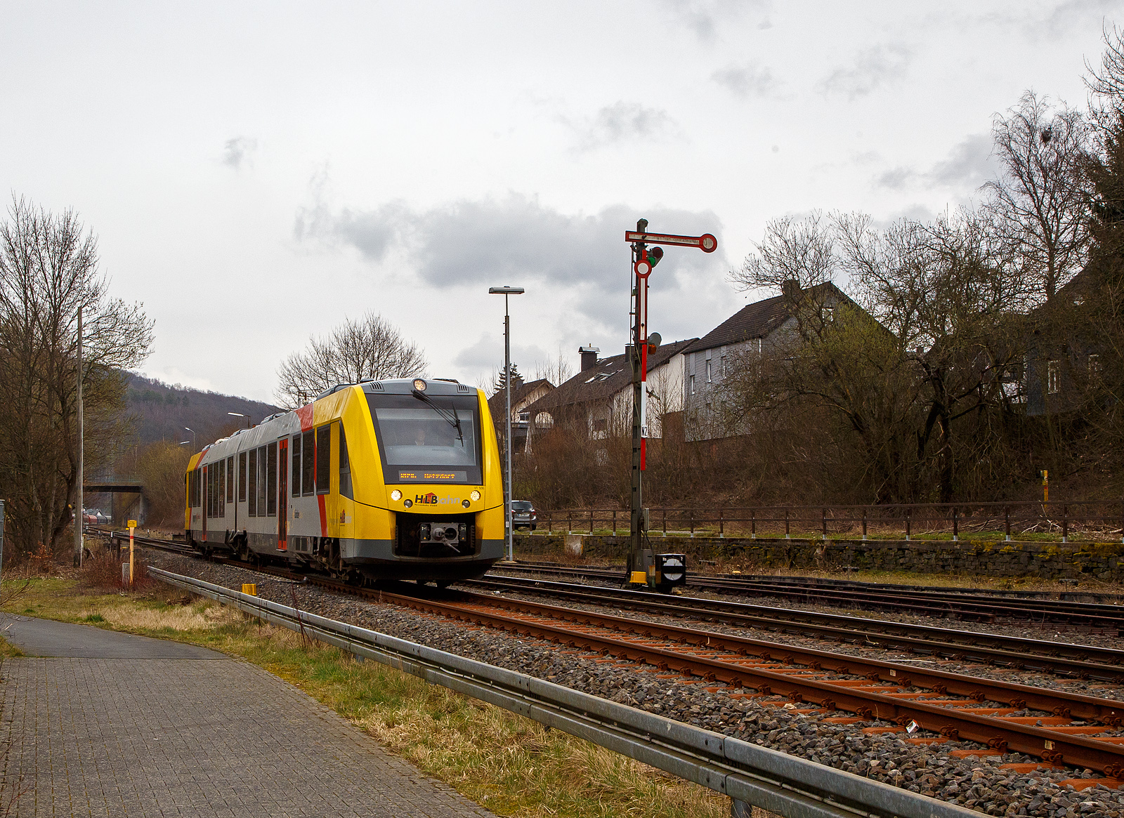 Nun fahren die Triebwagen der HLB RB 96 „Hellertalbahn“ auch endlich wieder den Bahnhof Herdorf an. Leider  ist aber dann in Herdorf am Hp Königstollen Schluss, ab dort gibt es dann von und nach Betzdorf (Sieg) SEV. Nach dem Hangrutsch (Felssturz) am 23. Dezember 2022 in Herdorf kurz hinter dem Hp  Königsstollen (bei km 88,4), ist der Abschnitt nach Betzdorf weiterhin bis mindestens bis zum kleinen Fahrplanwechsel am 11. Juni 2023, gesperrt. Aber diese ungewöhnliche Führung bis zum Hp  Königsstollen, über den Bahnhof Herdorf hinaus ist nötig, denn in den nächsten Tagen sollen die der Abriss und der Neubau der „Hellerbrücke“ der Hellerstraße (bei „Steinaus Eck“) beginnen und der SEV wäre so nur noch über Daaden oder Kirchen möglich.

Hier erreicht der VT 506 (95 80 1648 106-0 D-HEB / 95 80 1648 606-9 D-HEB), ein Alstom Coradia LINT 41 der neuen Generation / neue Kopfform, der HLB (Hessische Landesbahn GmbH) am 20.03.2023, als RB 96 „Hellertalbahn“ nach Betzdorf, bald den Bahnhof Herdorf.

Rechts das 1901 gebaute mechanische Weichenwärter Stellwerk Herdorf ost (Ho). Die beiden Stellwerke in Herdorf (Hf und Ho) sind in der Bauform Jüdel. Die Stellwerke der Bauform Jüdel (Max Jüdel & Co, Braunschweig) sind neben der Einheitsbauform am häufigsten in Deutschland anzutreffen. Viele andere Stellwerkshersteller haben Jüdel-Stellwerke in Lizenz gefertigt und dabei mehr oder weniger starke Änderungen vorgenommen.