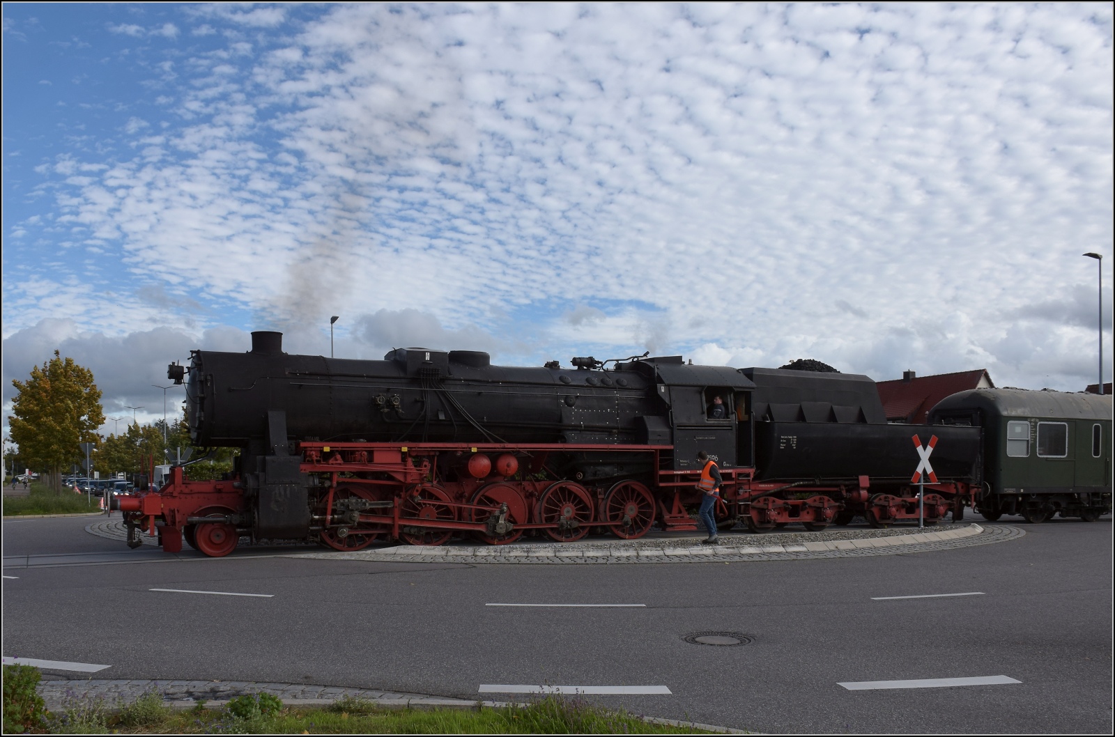 Schienenverkehr unterm Hohentwiel. 

52 7596 mit ihrem EFZ-Sonderzug für die SEHR & RS auf der dritten Station der Bahnübergangsralley in Singen mitten auf dem Kreisverkehr der Georg-Fischer-Strasse. Oktober 2022.